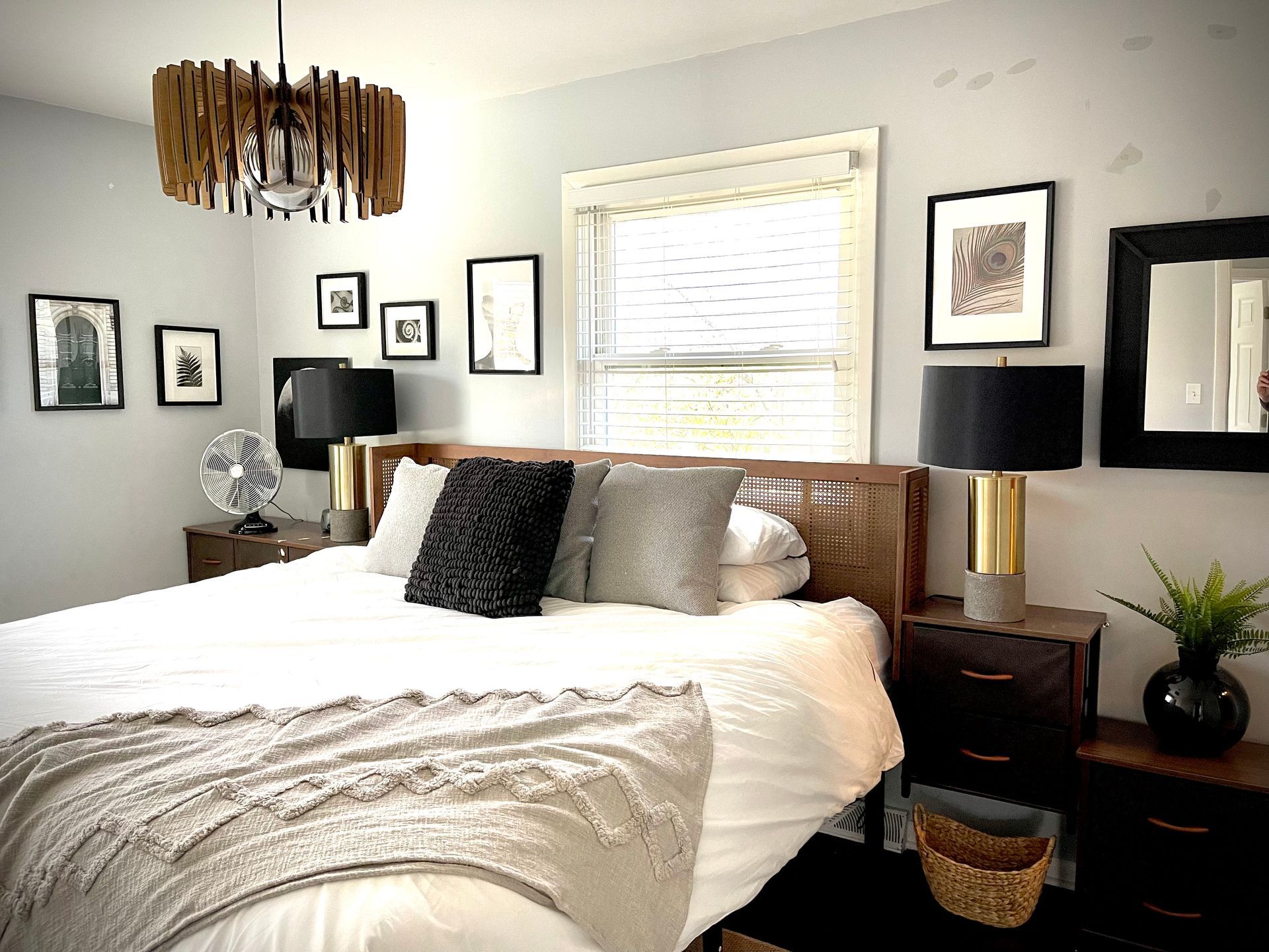 A bedroom with a bed , nightstands , lamps and a window.