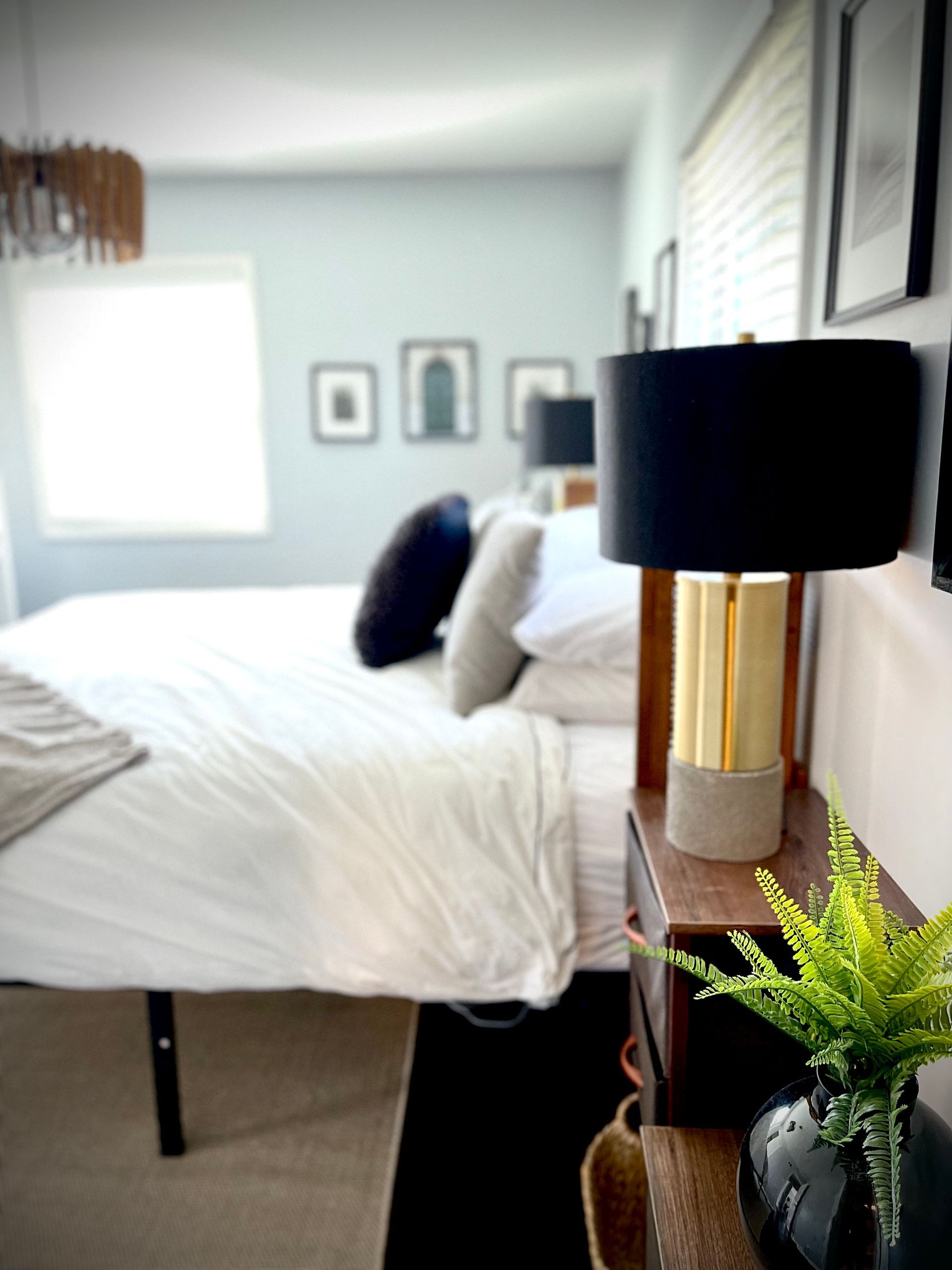 A bedroom with a bed and a lamp on a nightstand