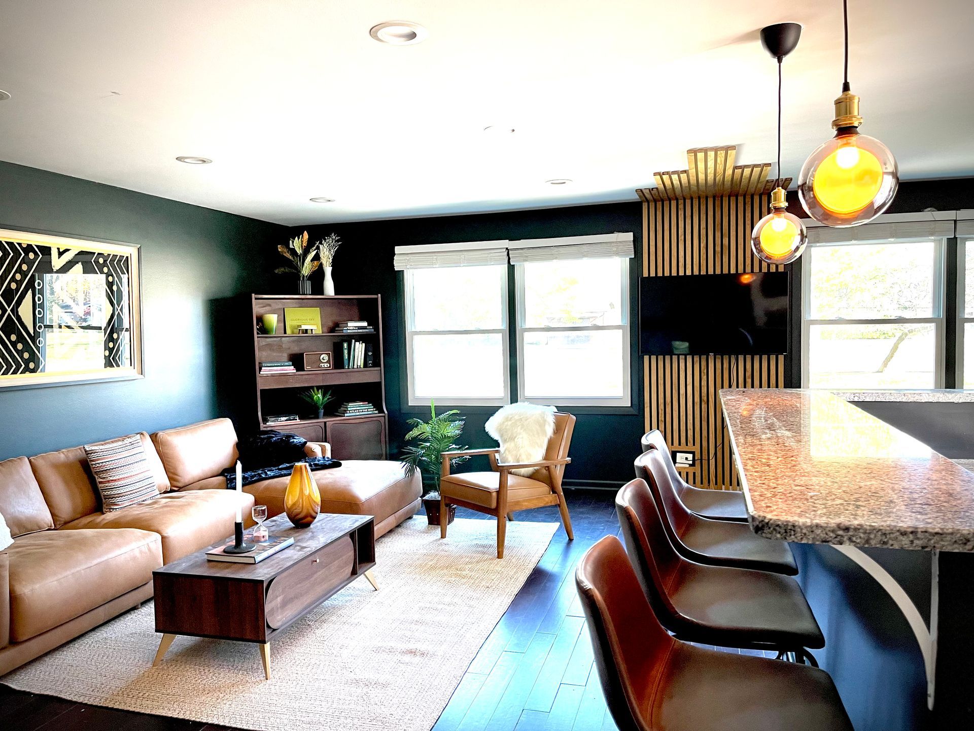 A living room with a couch , chairs , table and television.