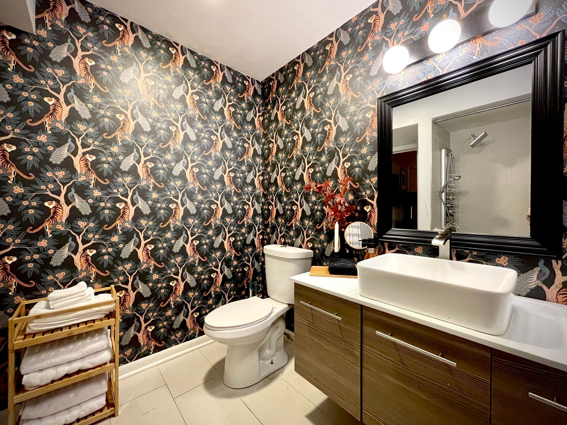 A bathroom with a toilet , sink and mirror.