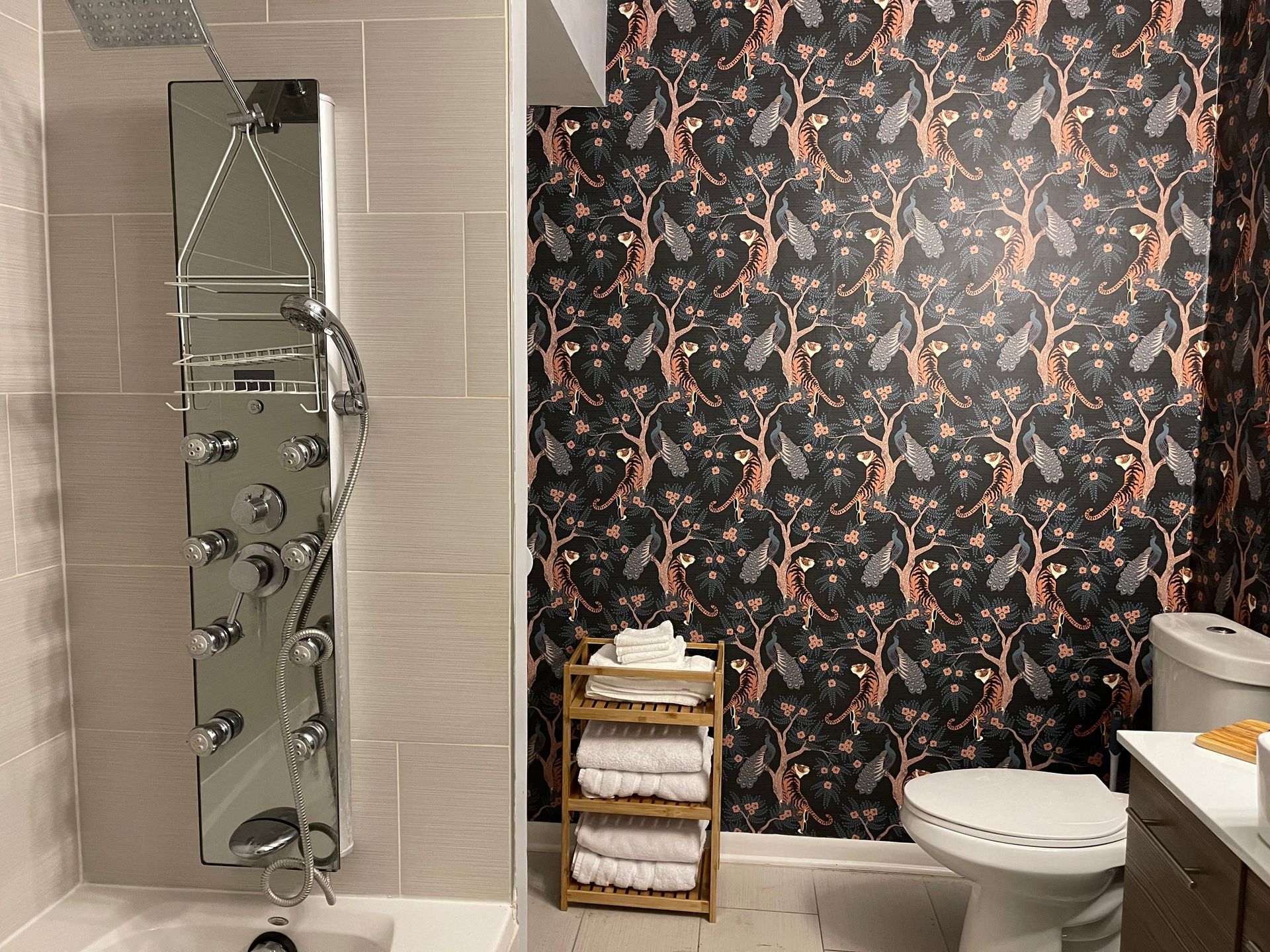 A bathroom with a toilet , sink , shower , and towel rack.