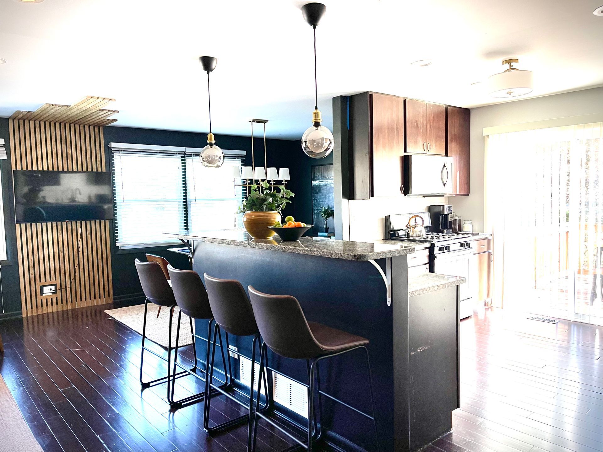 A kitchen with a large island and stools in it