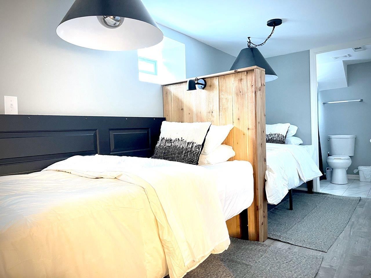 A bedroom with two beds and a toilet.