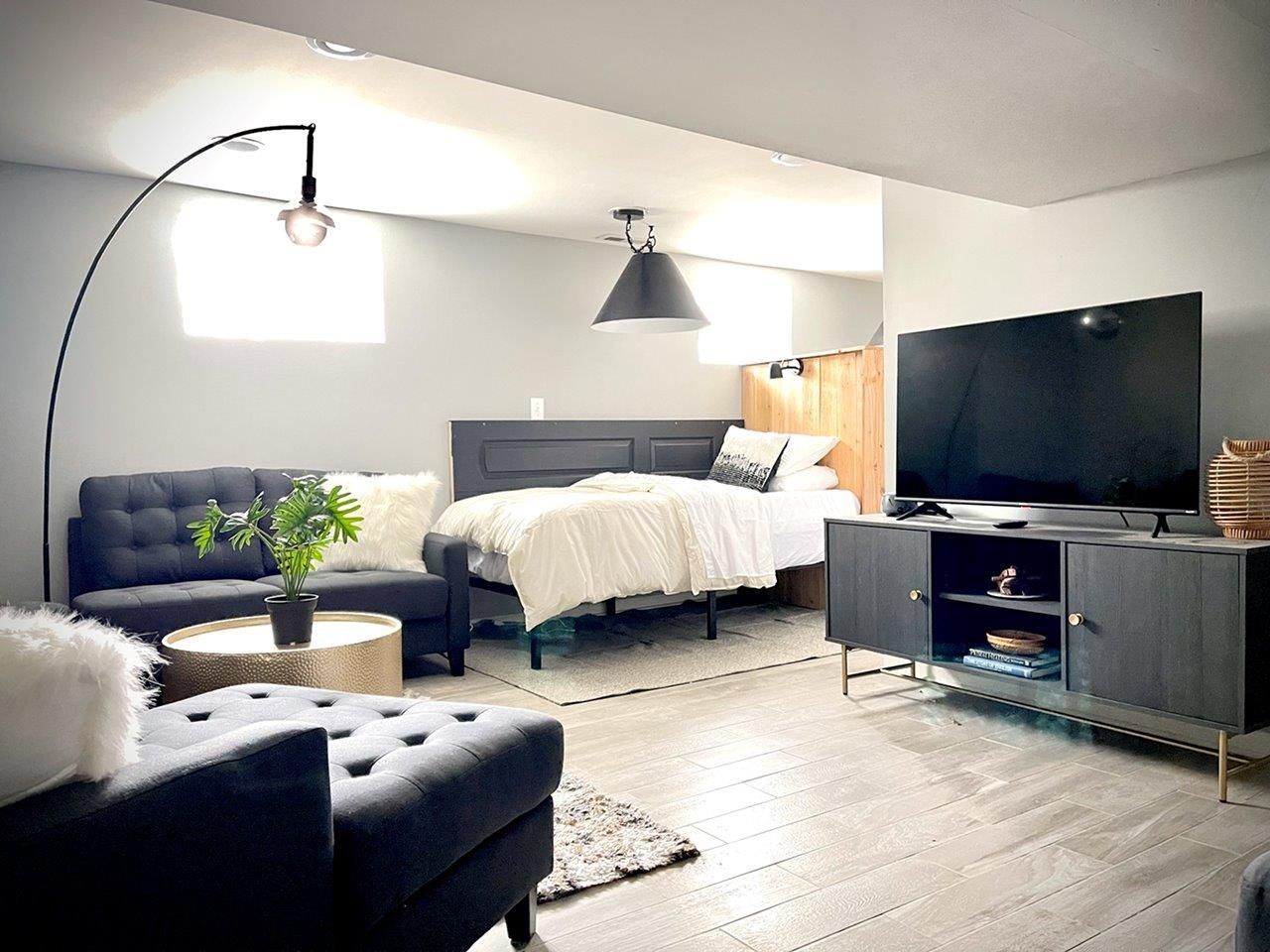 A living room with a bed , couch , chair and television.