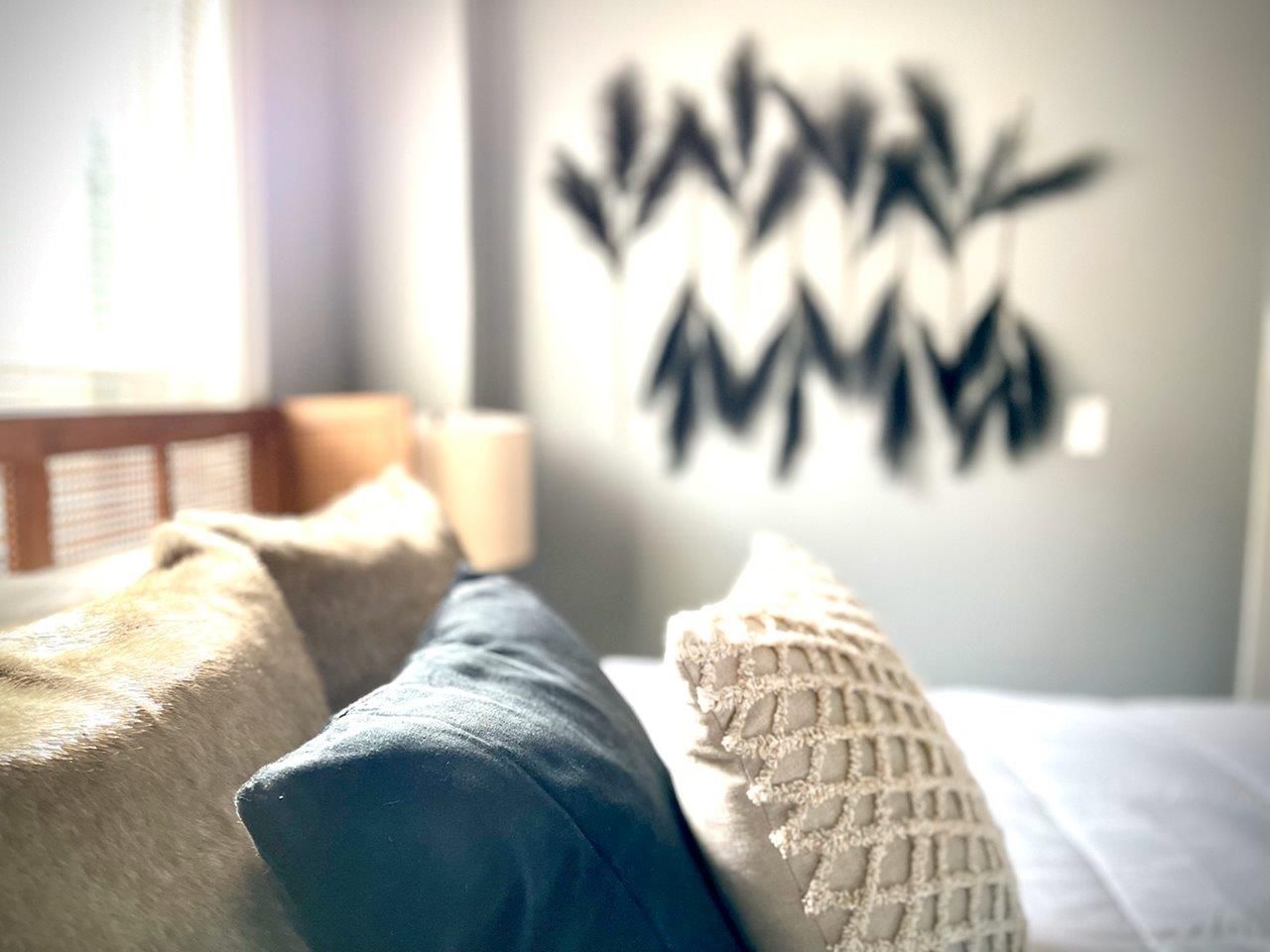 A bedroom with a couch and pillows and a wall that says ' www ' on it