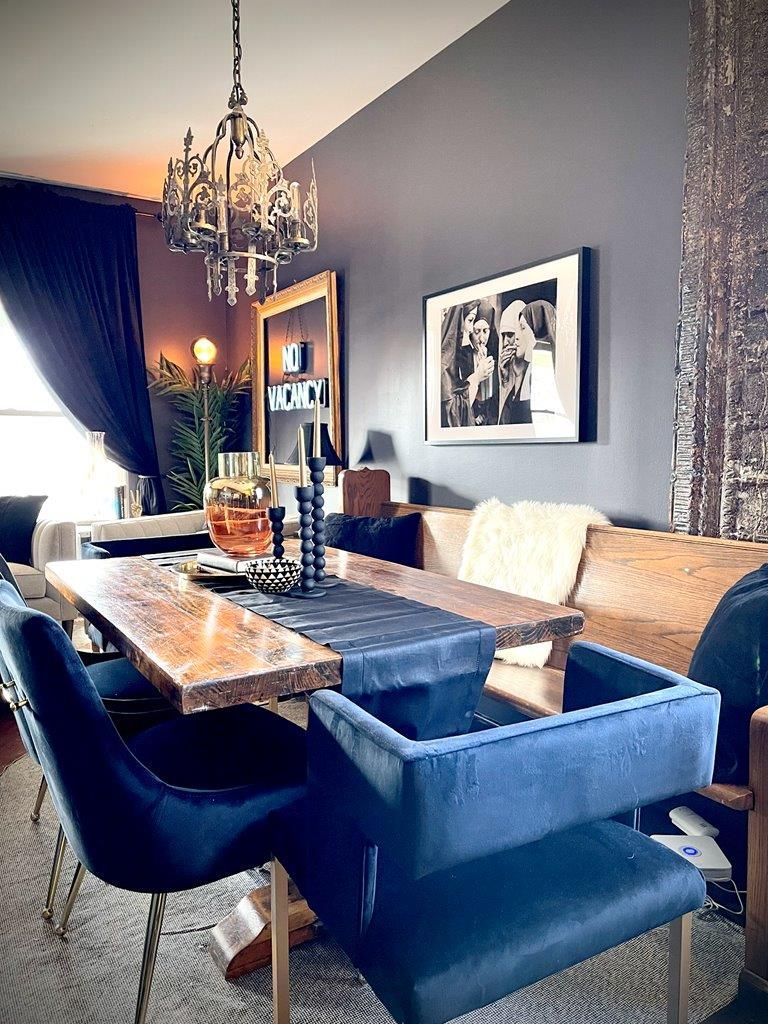 A living room with a table and chairs and a chandelier.