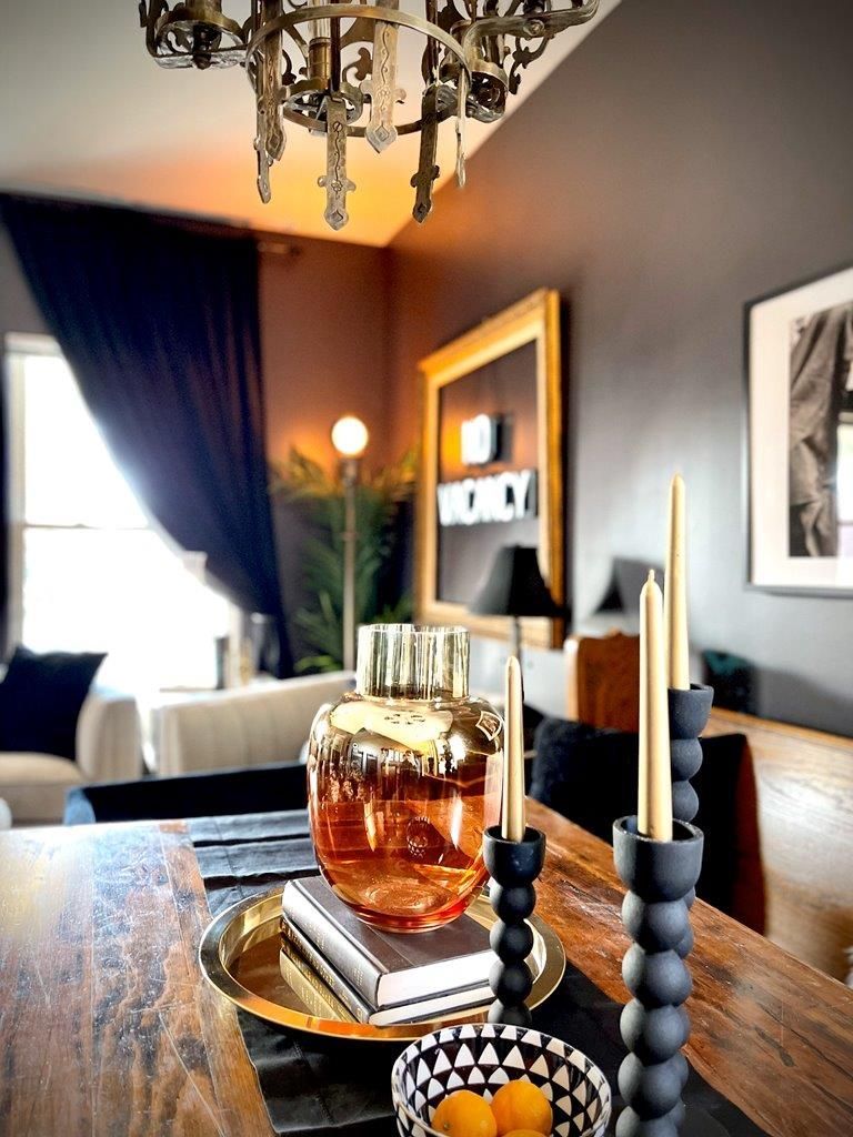 A dining room table with candles and a bottle of perfume on it