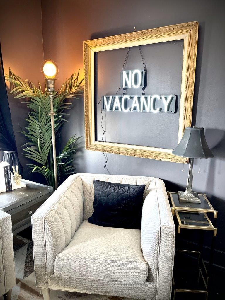 A room with a chair and a sign that says no vacancy.