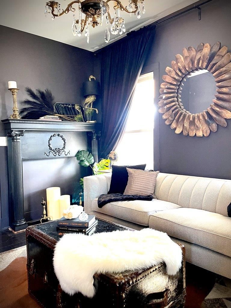 A living room with a couch , coffee table , fireplace and mirror.