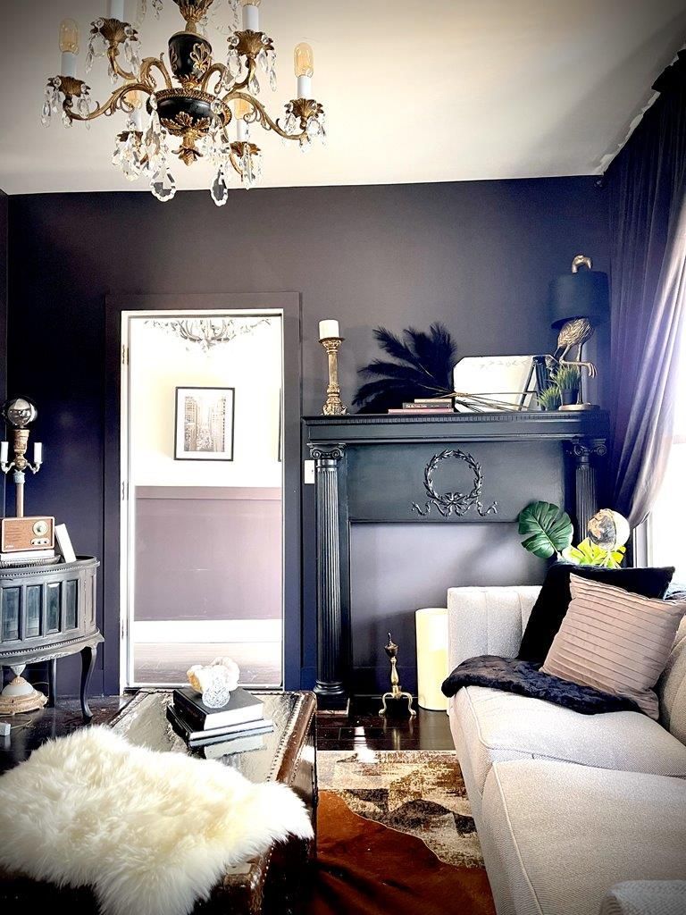 A living room with a couch a fireplace and a chandelier