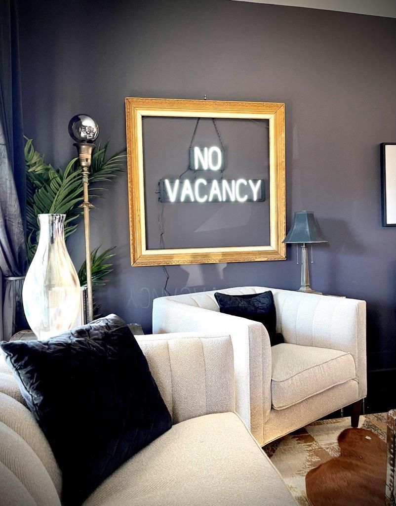 A living room with a no vacancy sign on the wall