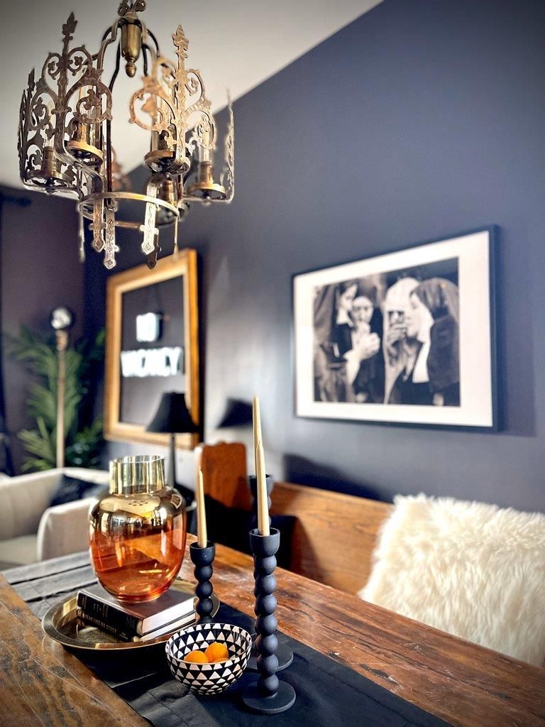 A dining room table with candles and a picture on the wall