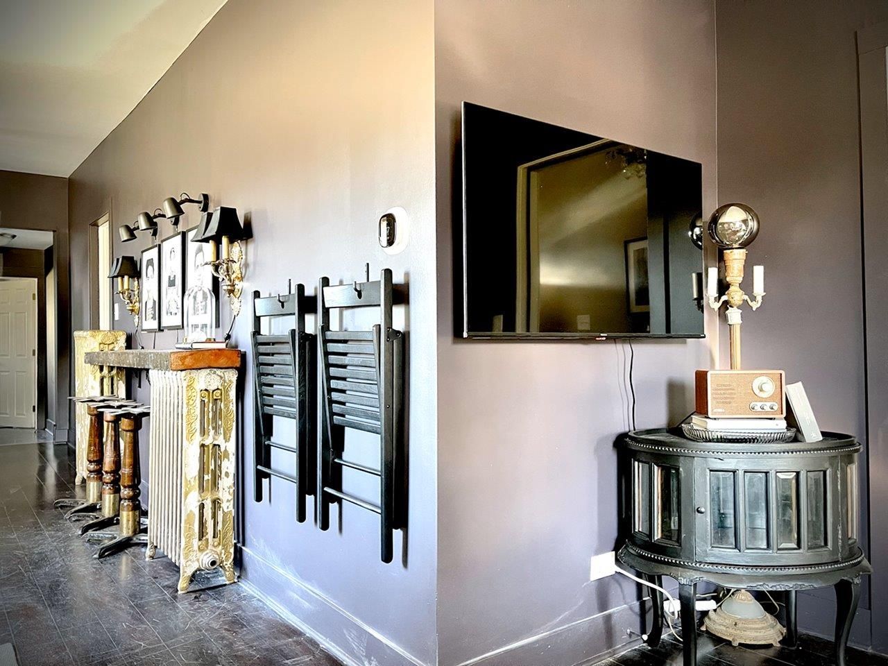 A living room with a large flat screen tv on the wall.