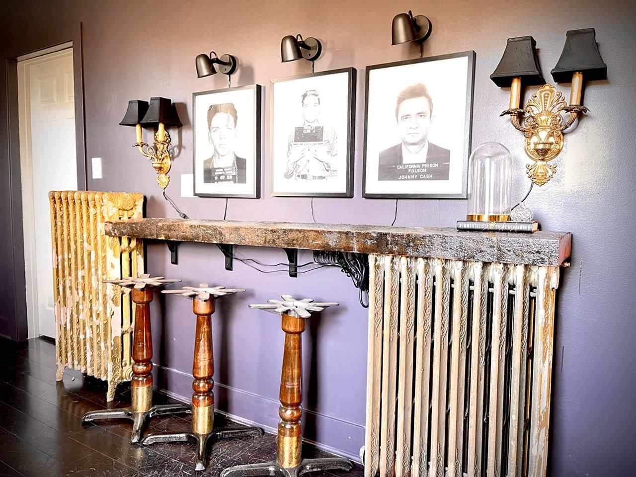 A room with a table and stools and pictures on the wall