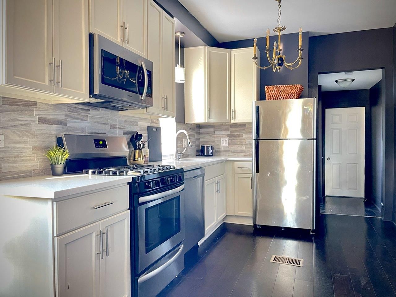 A kitchen with stainless steel appliances and white cabinets