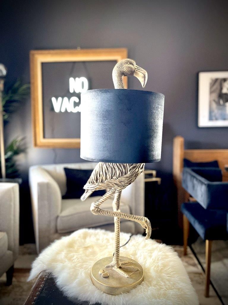 A lamp with a flamingo on it is sitting on a table in a living room.