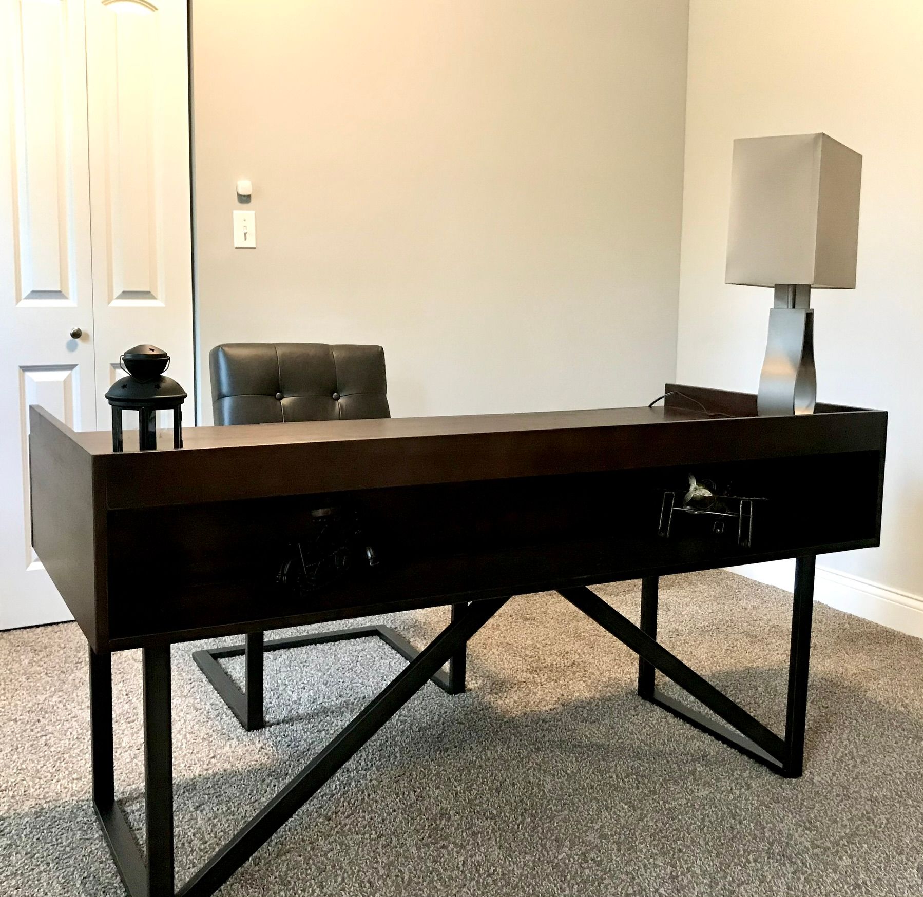 A desk and chair in a room with a lamp