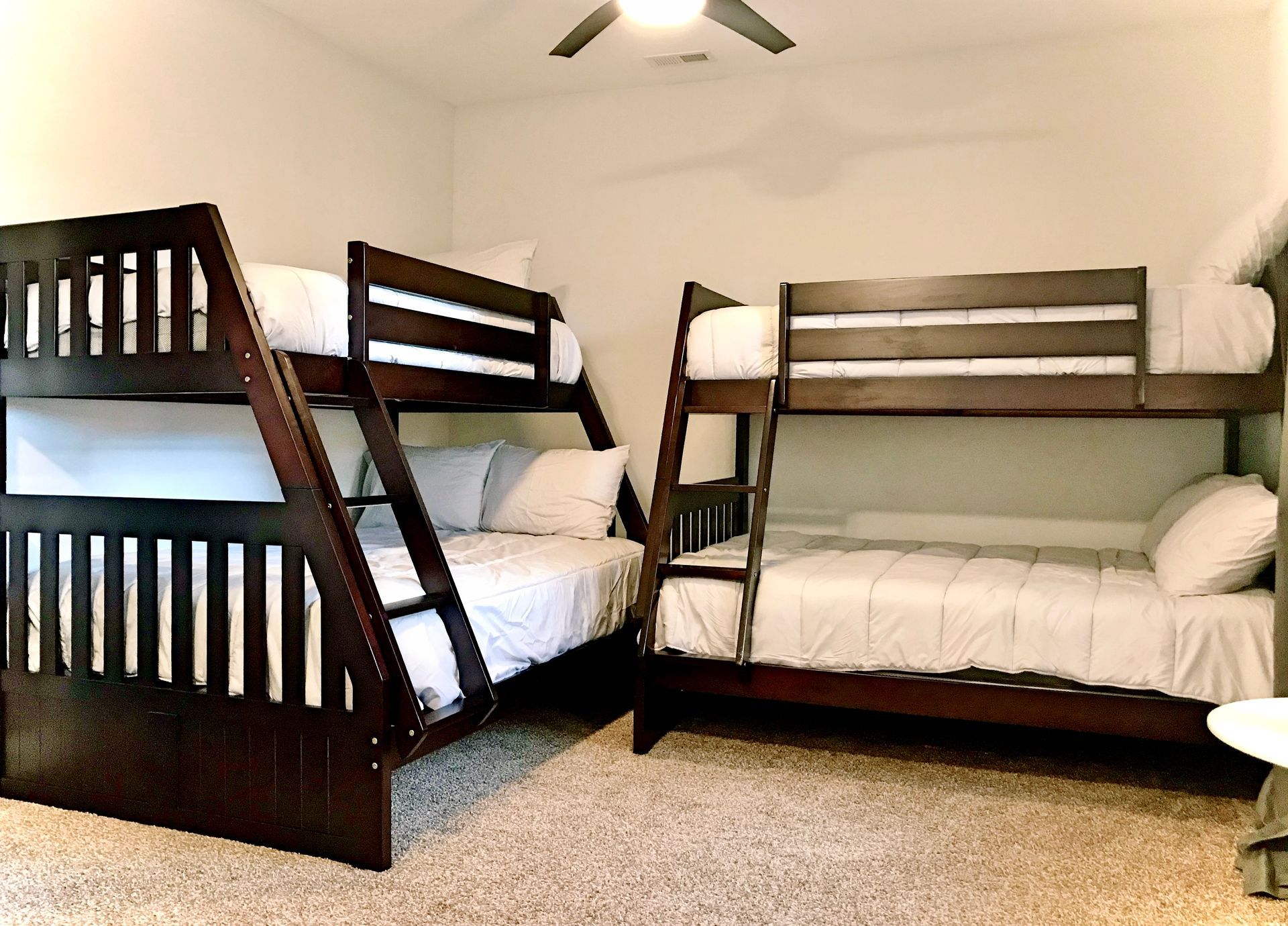 A bedroom with three bunk beds and a ceiling fan.