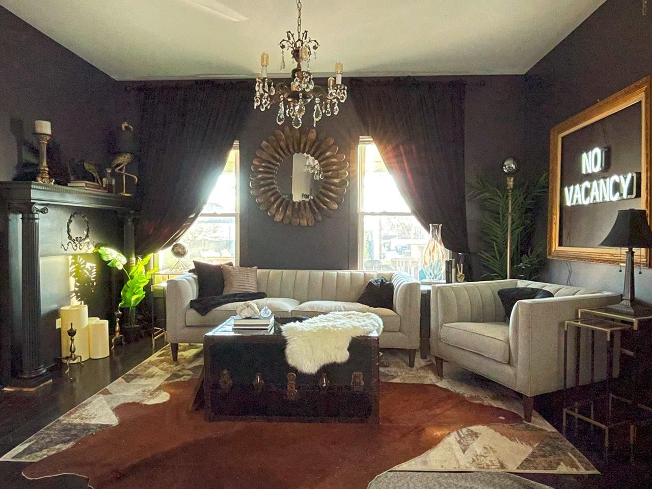 A living room with a couch , chairs , coffee table and a sign that says no vacancy.