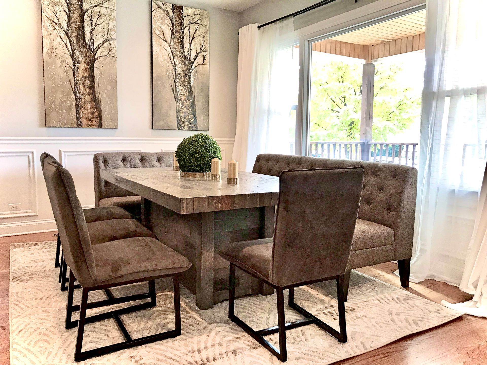 A dining room with a table and chairs and a bench.