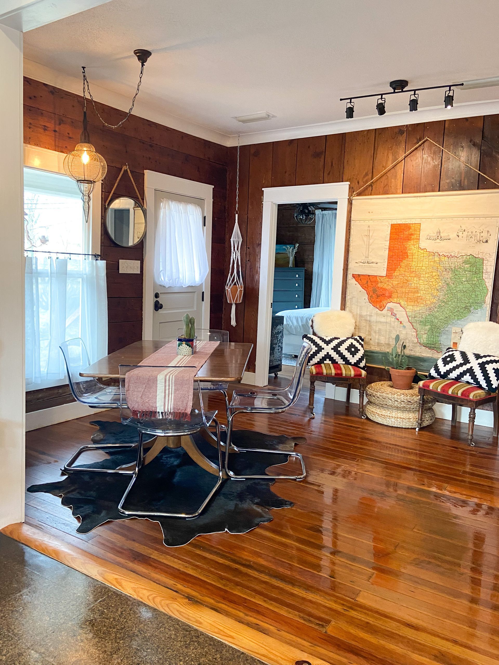 A living room with a table and chairs and a map on the wall.