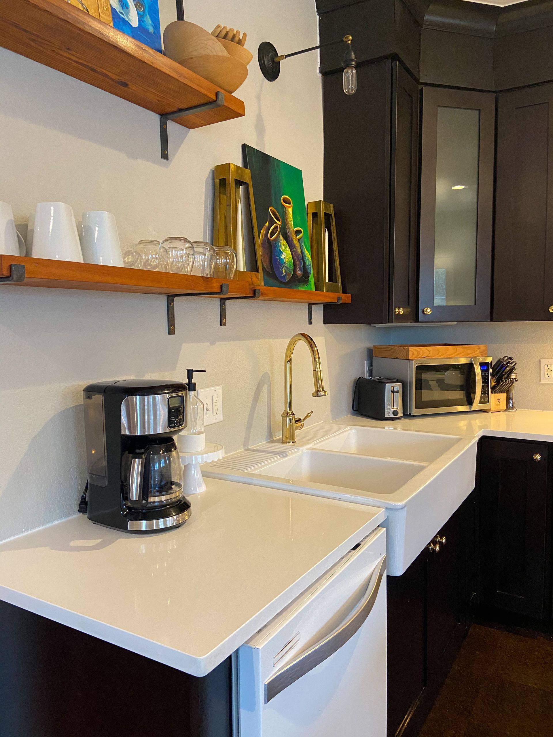 A kitchen with two sinks and a coffee maker on the counter