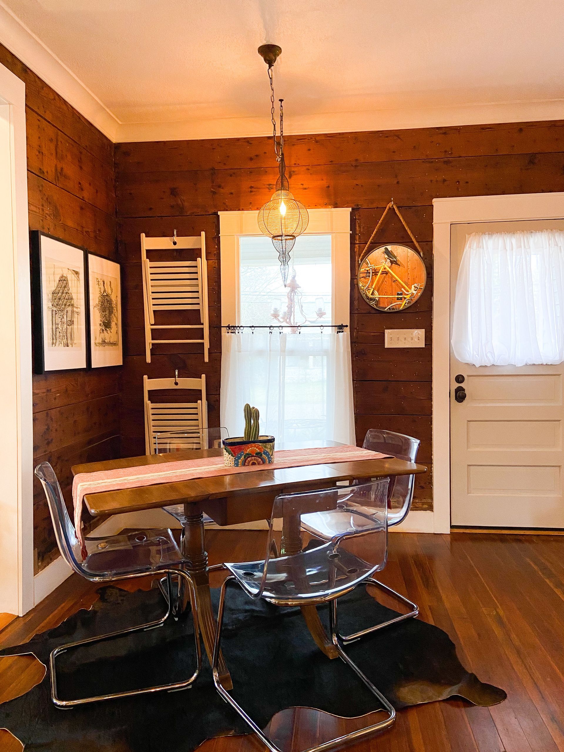 A dining room with a table and chairs and a cowhide rug