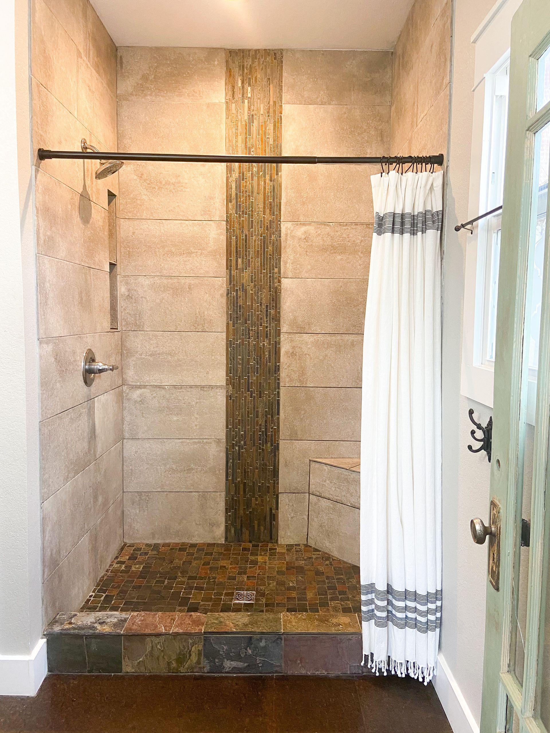 A bathroom with a walk in shower and a shower curtain.