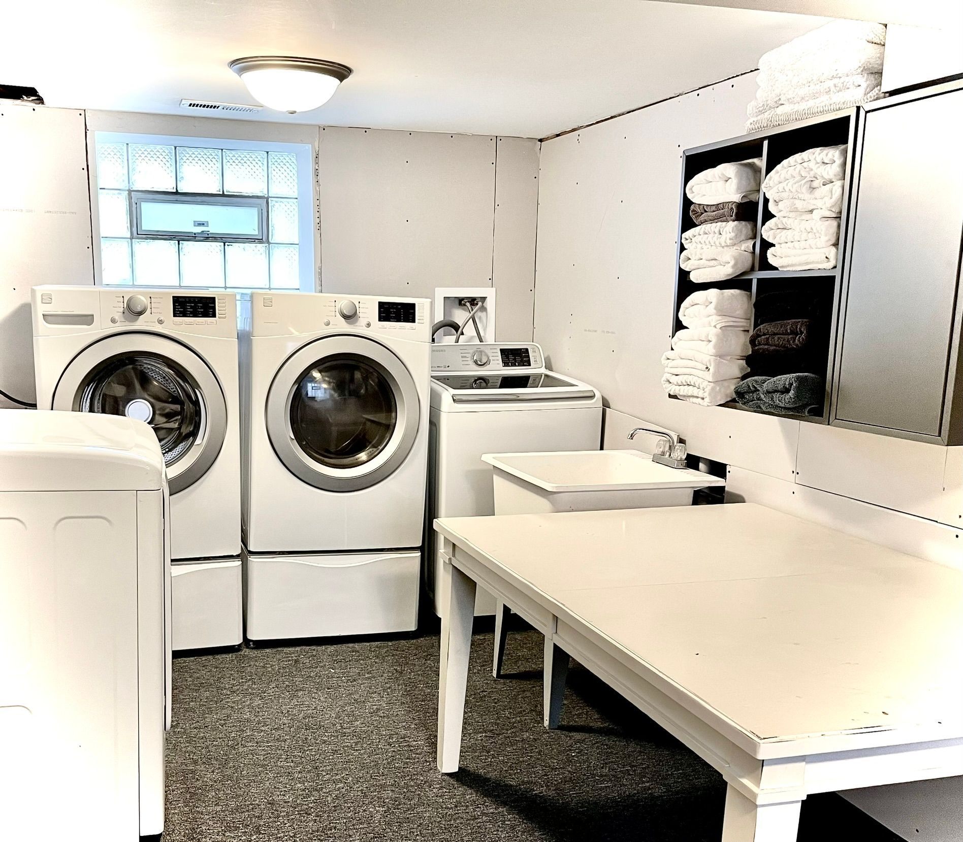 A laundry room with two washers and two dryers