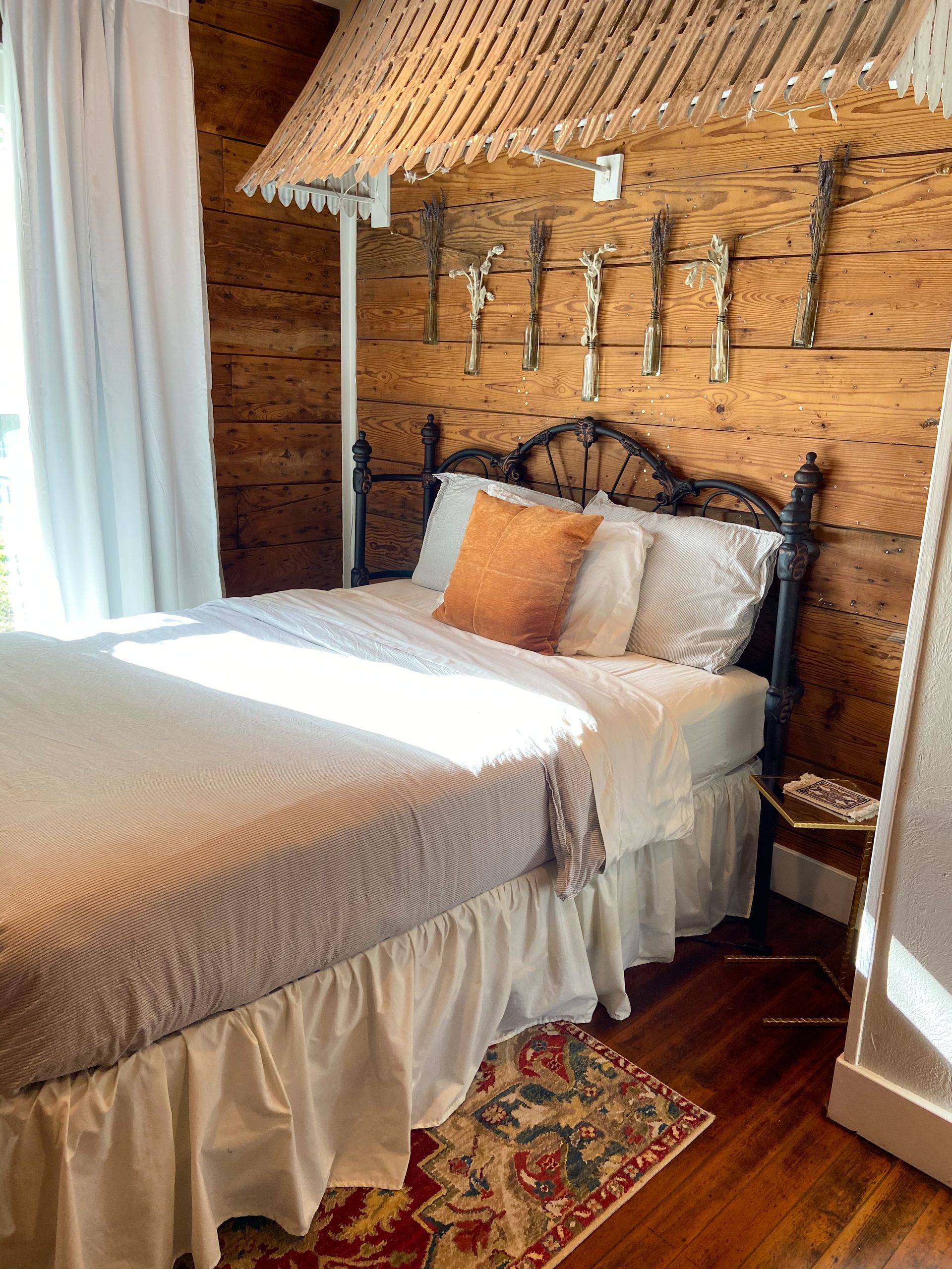 A bedroom with a bed and a wooden wall.