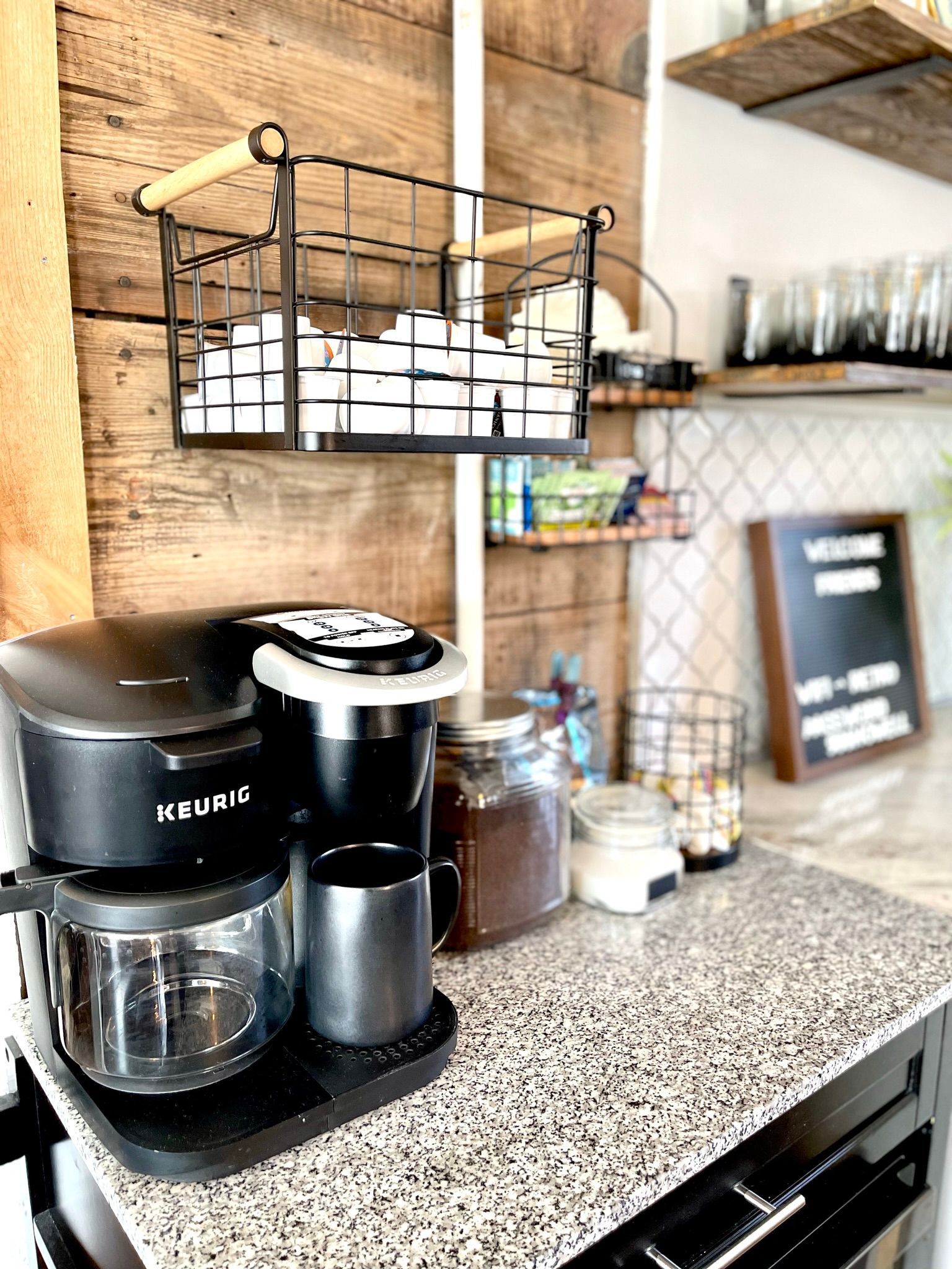 A coffee maker is sitting on top of a granite counter in a kitchen.