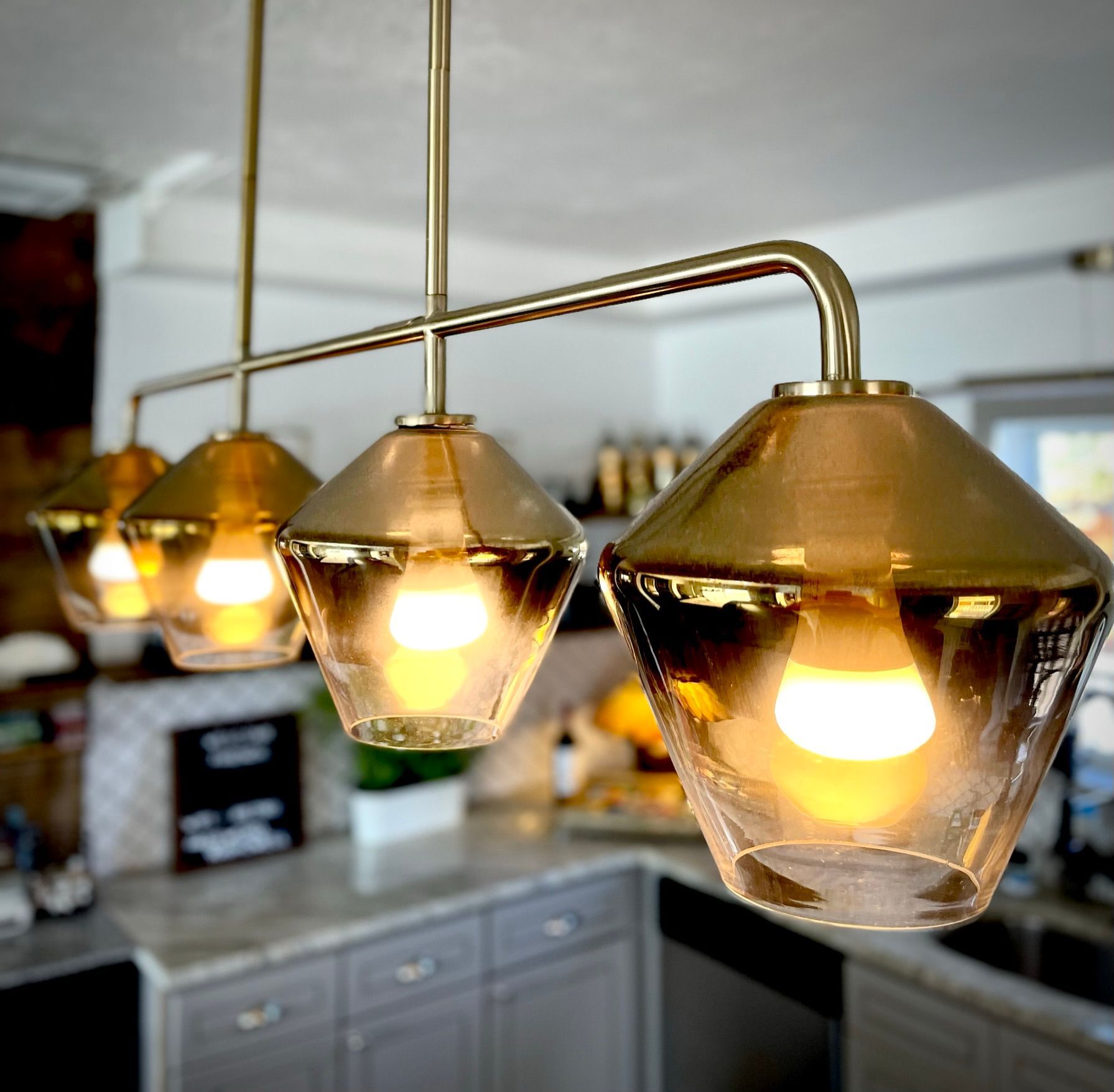 A kitchen with a lot of lights hanging from the ceiling