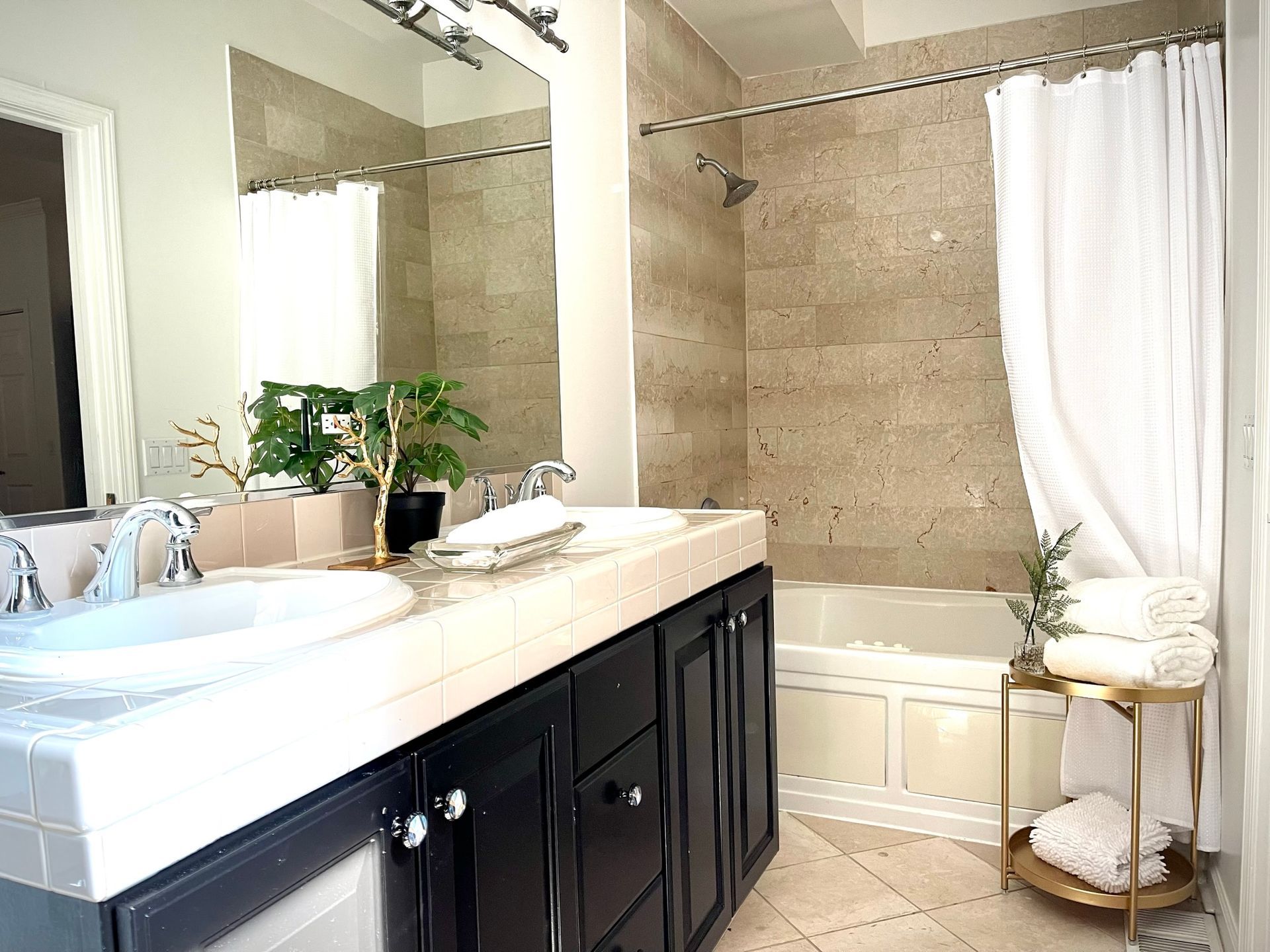 A bathroom with a sink , tub , shower and mirror