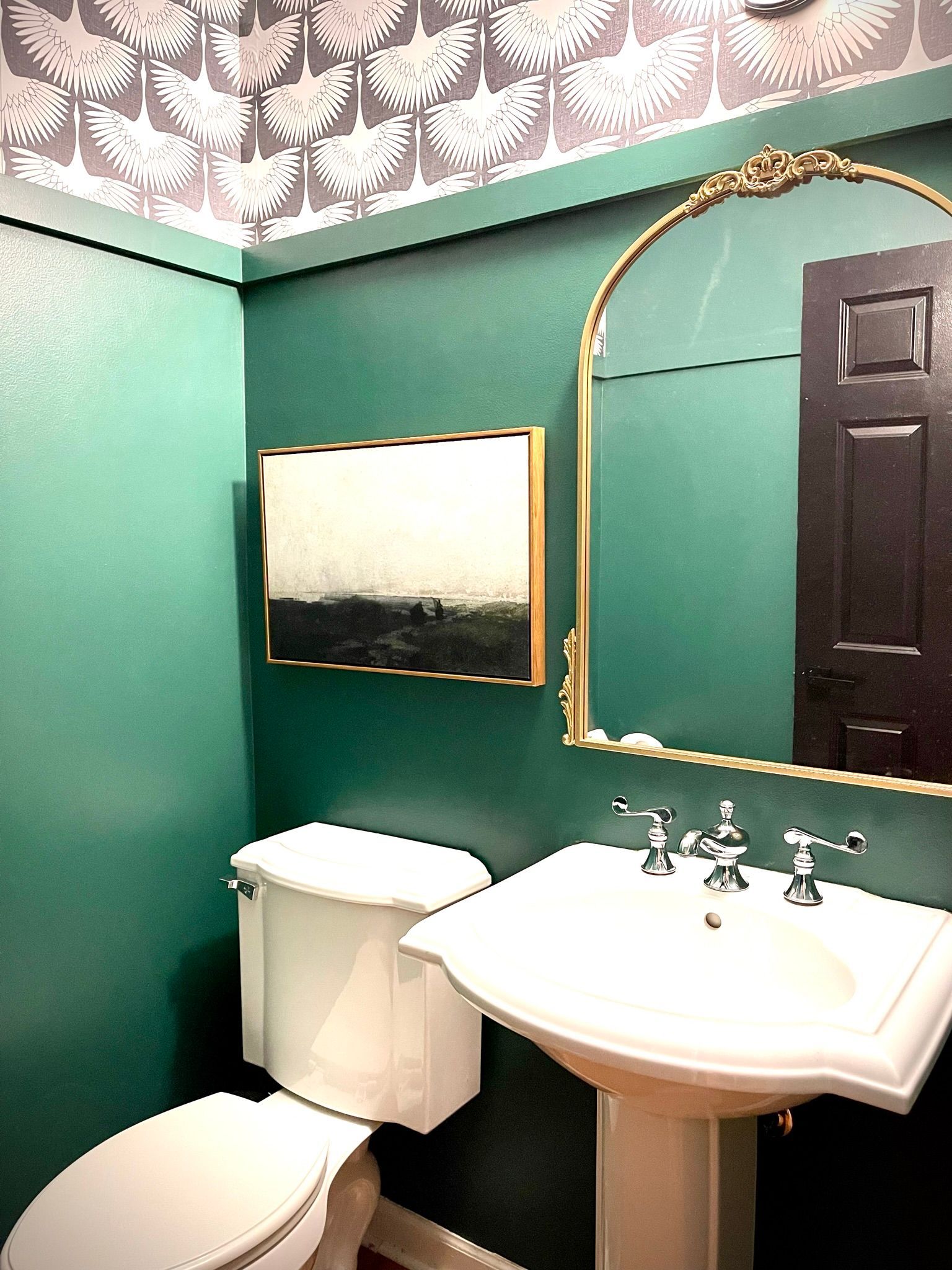 A bathroom with a toilet , sink and mirror