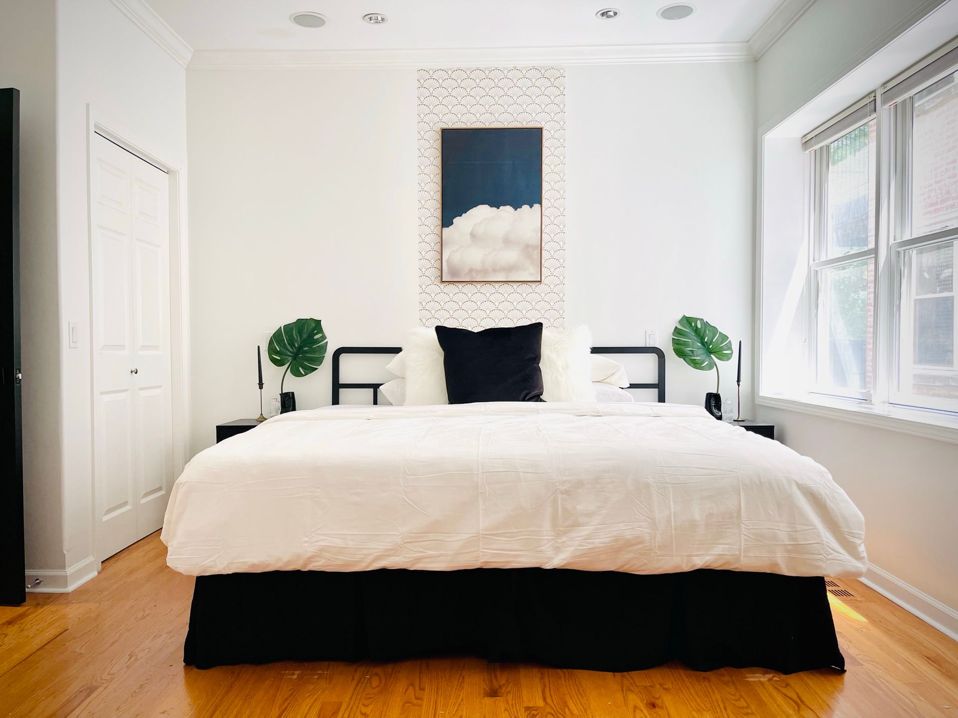 A bedroom with a large bed and a painting on the wall.