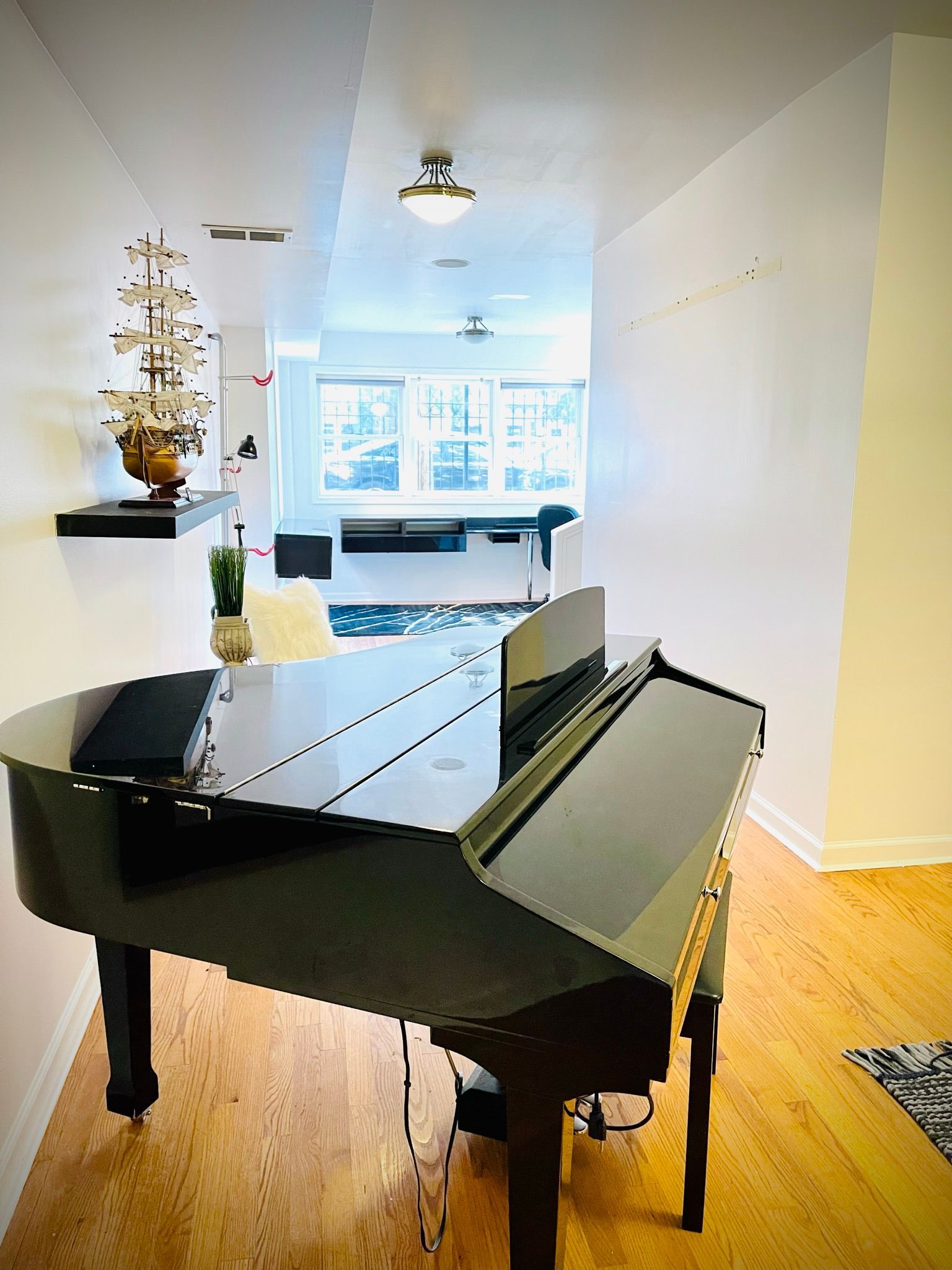 A black grand piano is sitting in a living room.