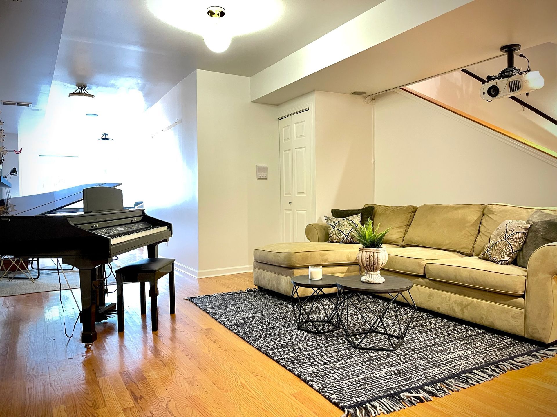 A living room with a couch , piano , and rug.