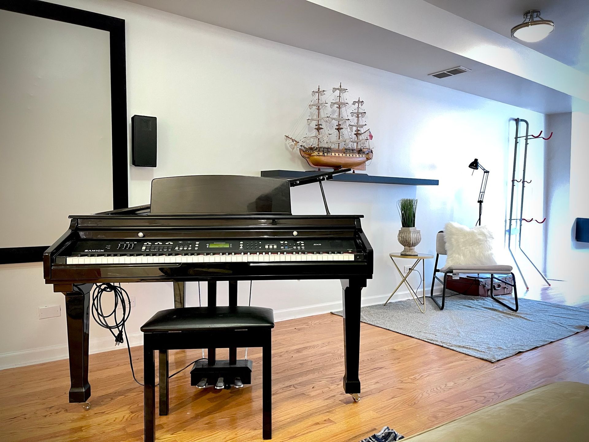 A piano is sitting in a living room next to a chair
