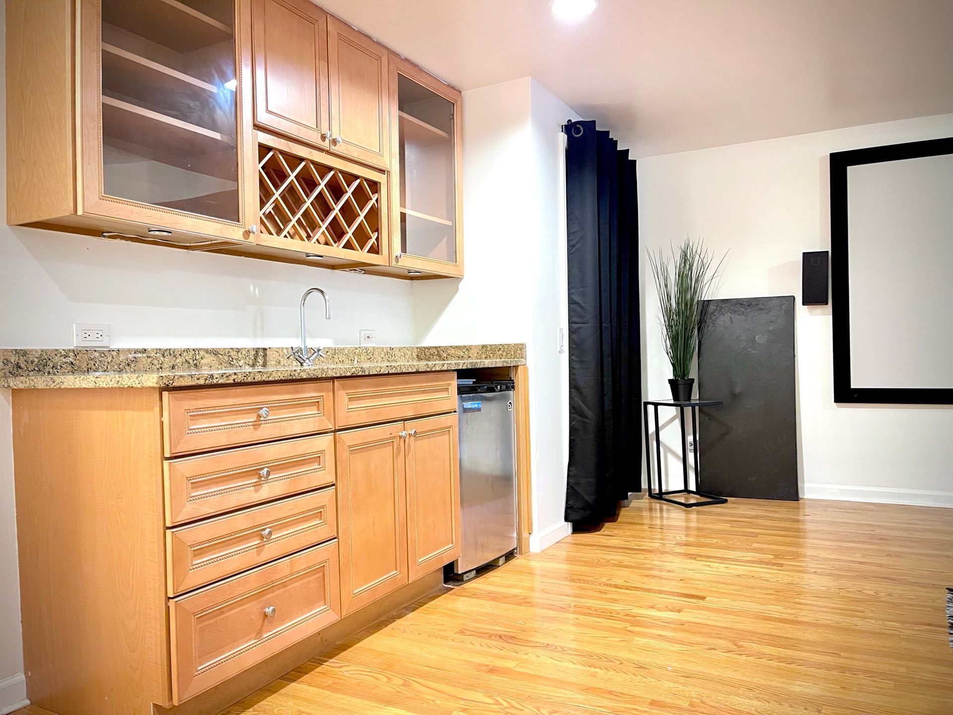 A kitchen with wooden cabinets and a projector screen