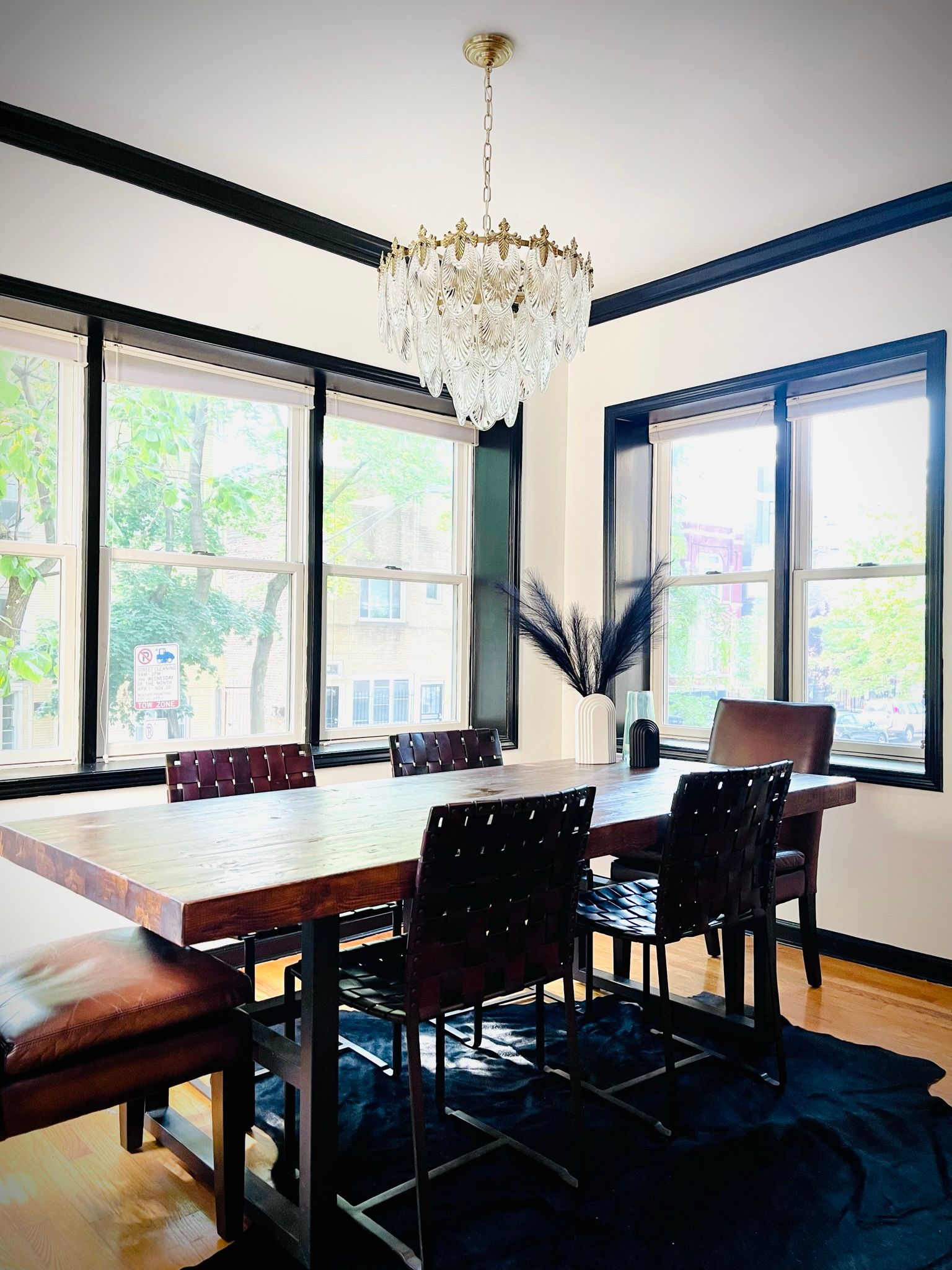 A dining room with a table and chairs and a chandelier hanging from the ceiling.