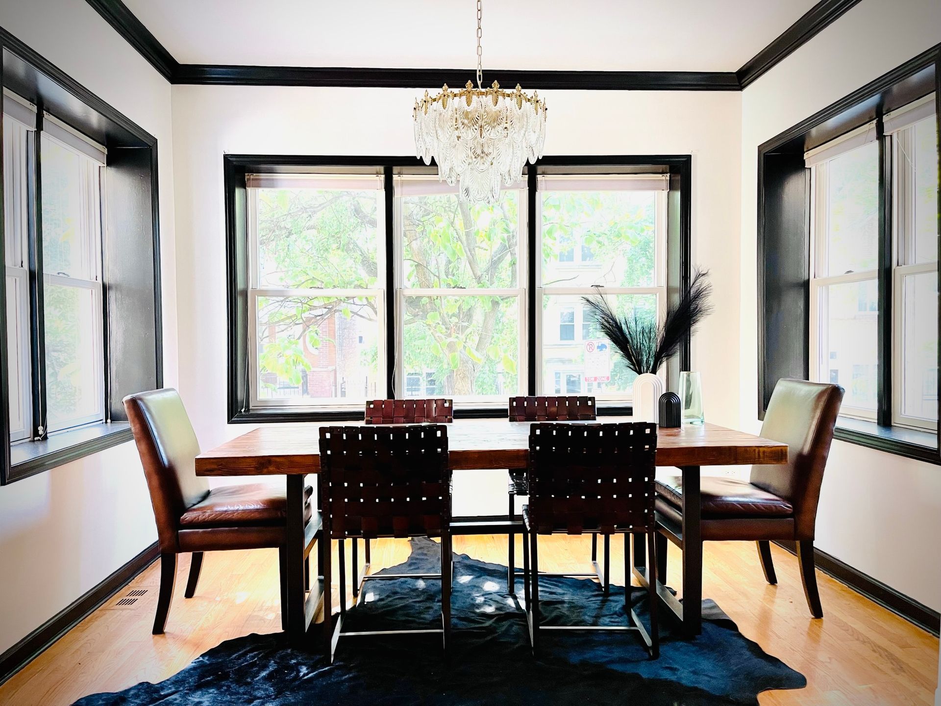 A dining room with a table and chairs and a chandelier.