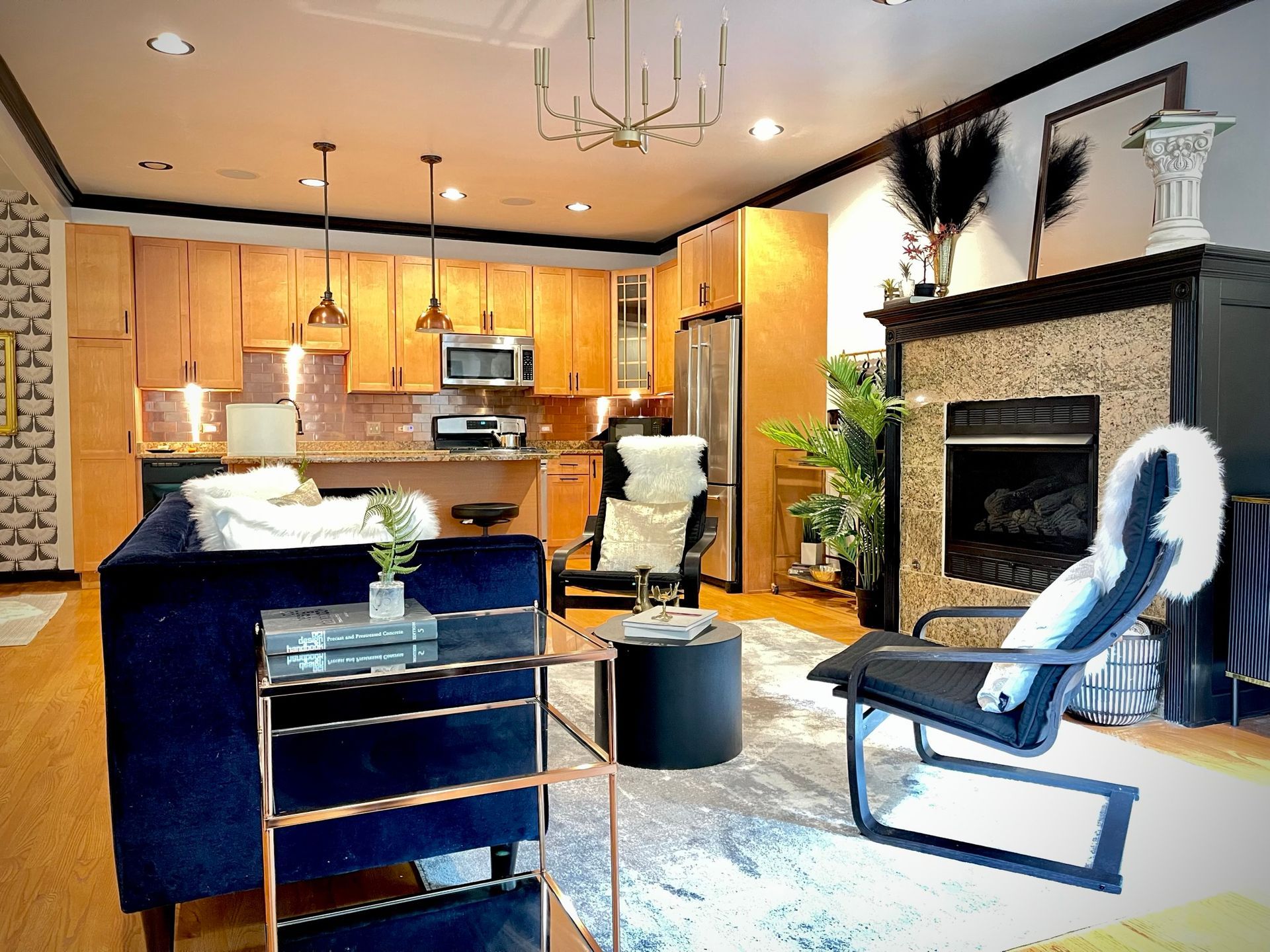 A living room with a couch , chair , table and fireplace.