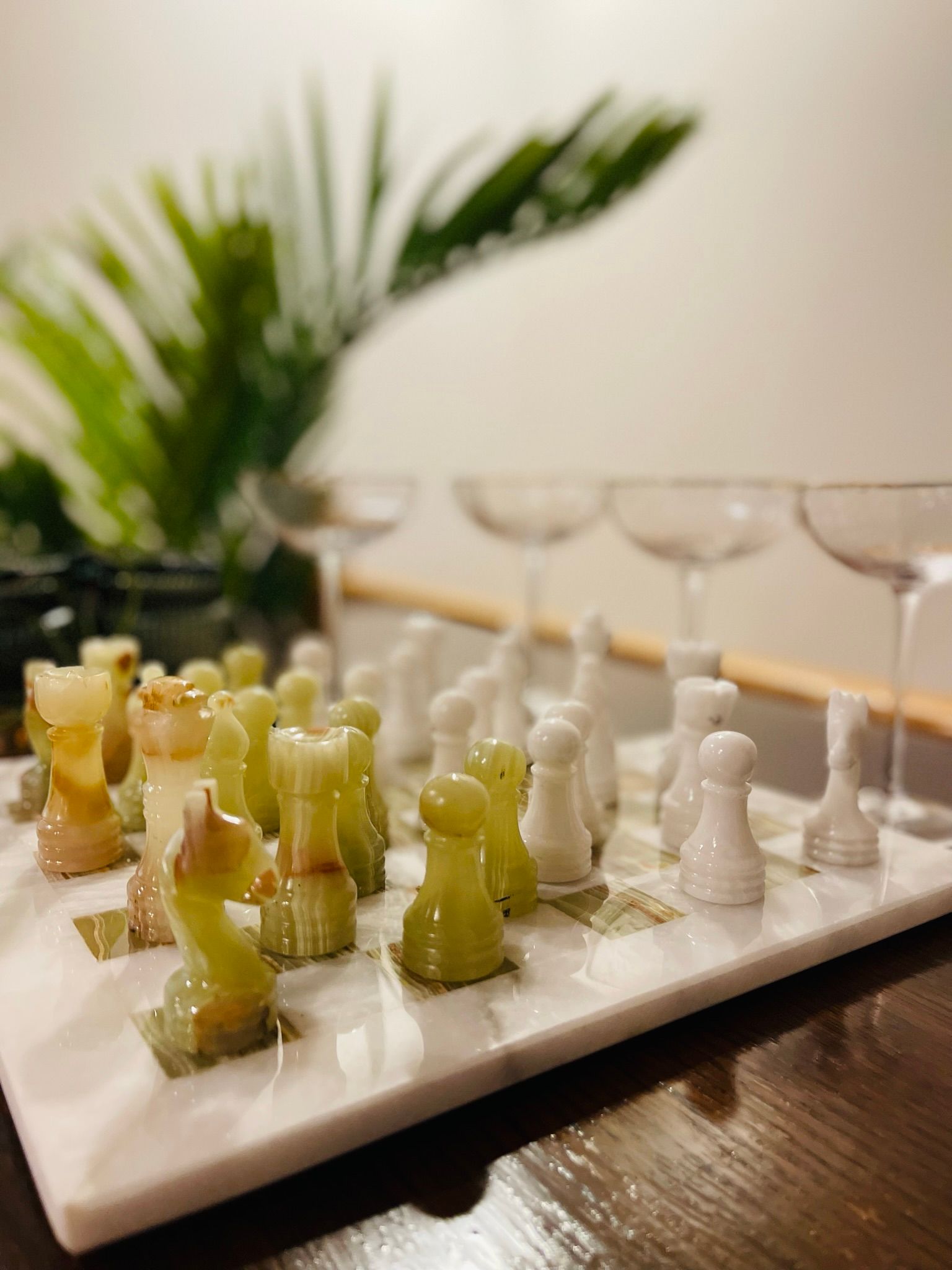 A chess set is sitting on a white plate on a table.