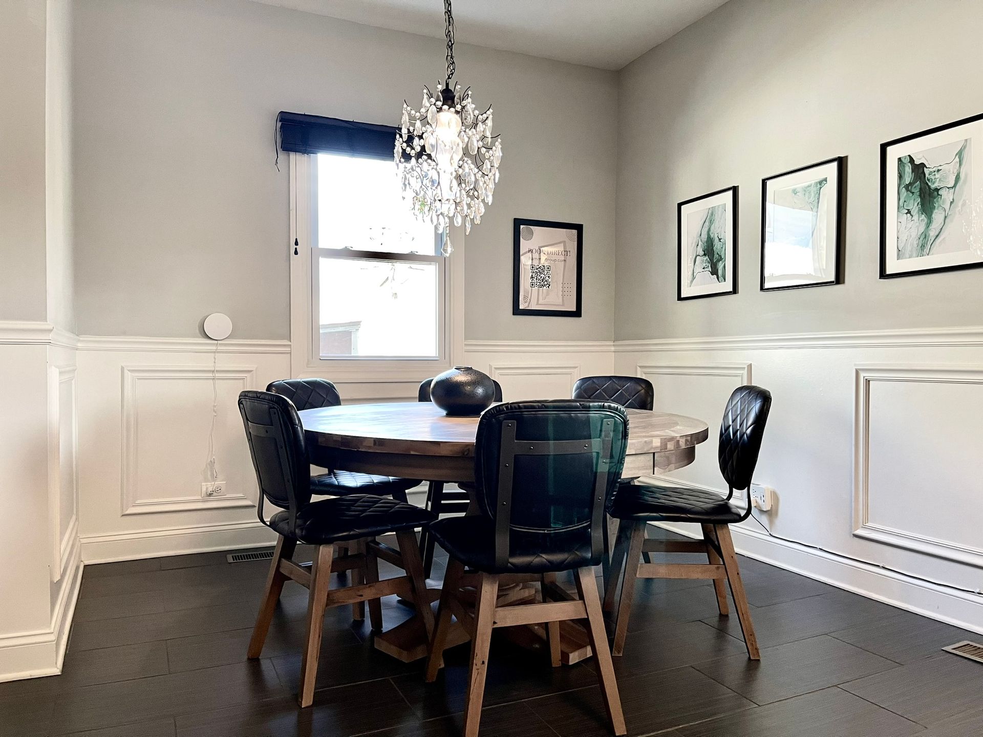 A dining room with a table and chairs and a chandelier