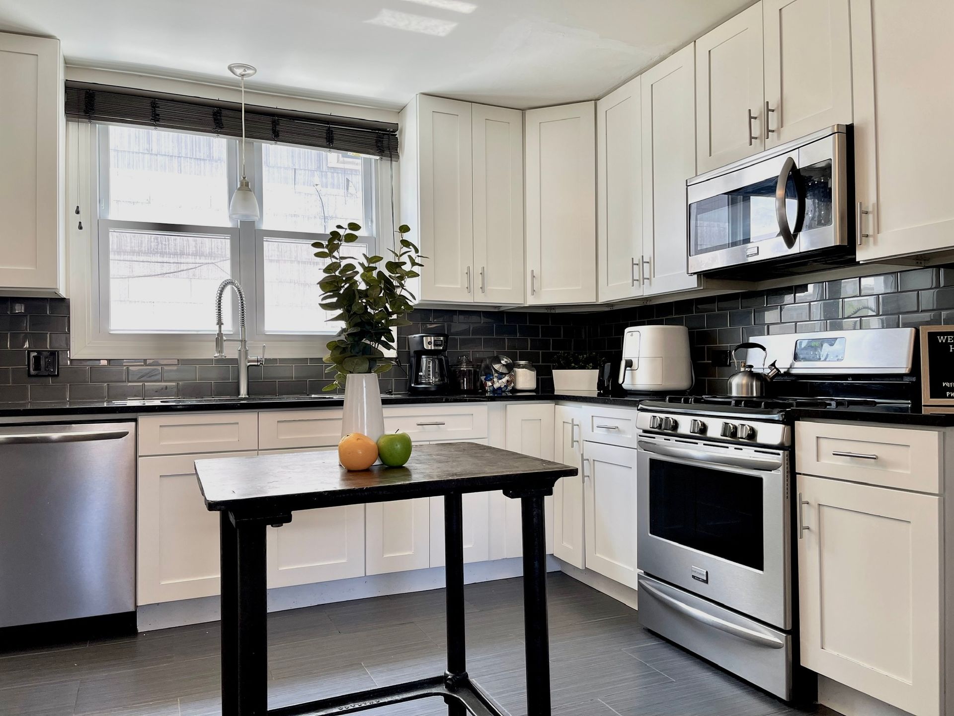 A kitchen with white cabinets and stainless steel appliances