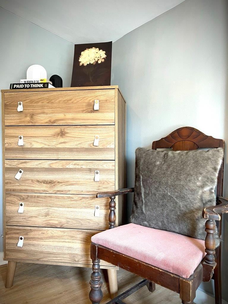 There is a chair and a dresser in the room.