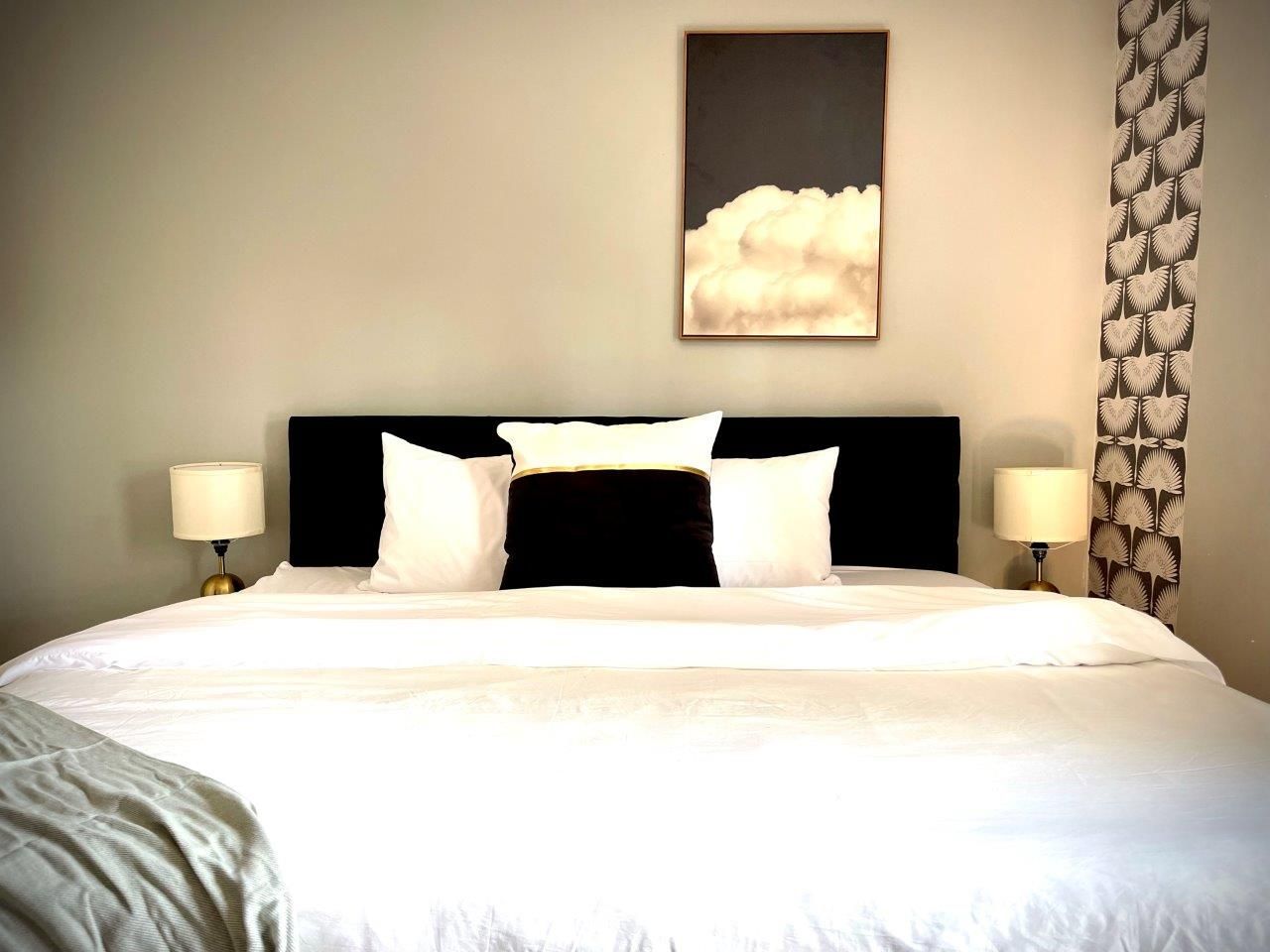 There is a painting on the wall above the bed.