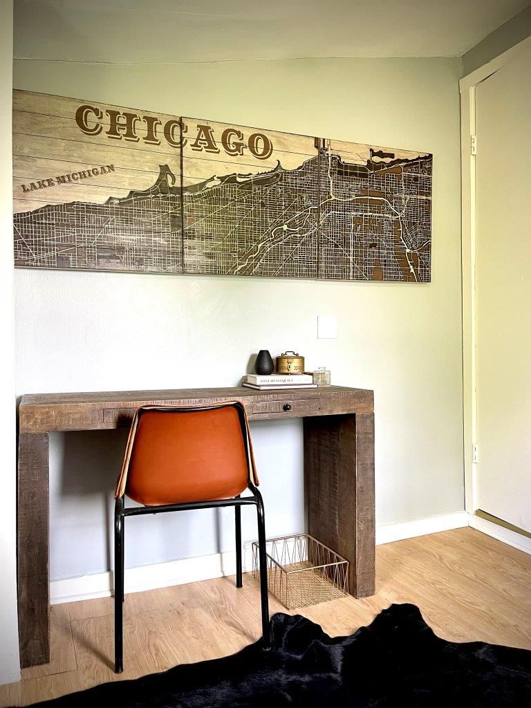 A desk with a chair and a large chicago map on the wall above it.