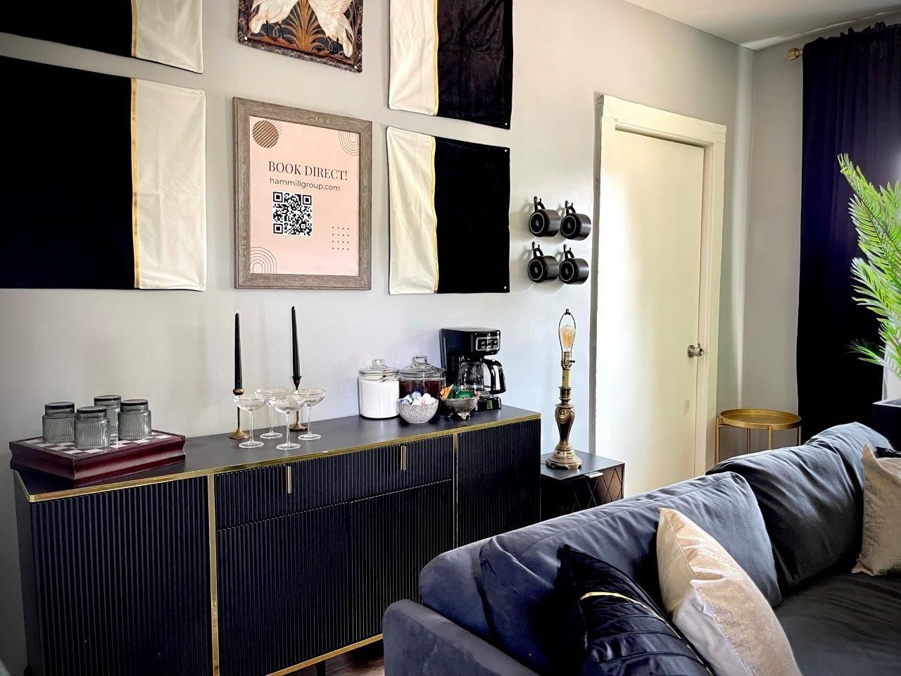 A living room with a couch , dresser , and mirrors.