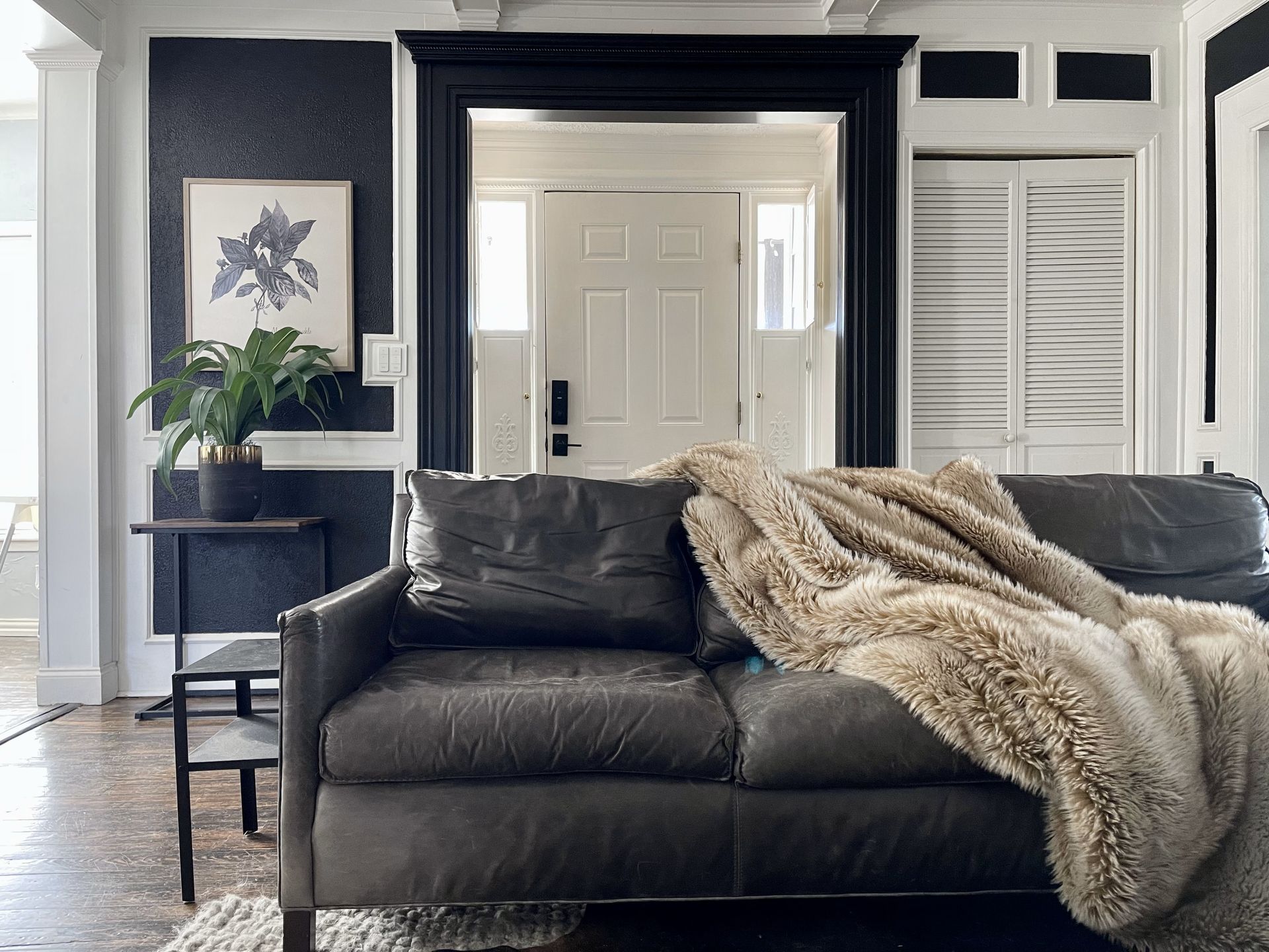 A living room with a couch and a blanket on it
